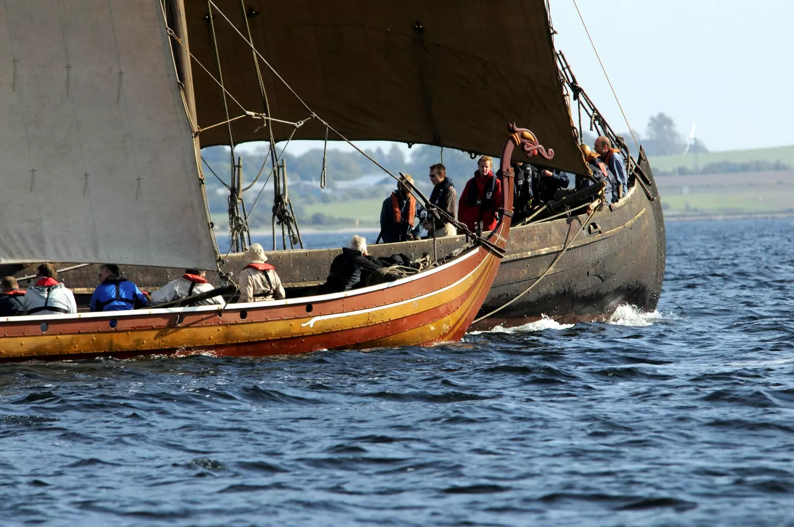 Două replică de nave vikinge care navighează prin fiordul Roskilde