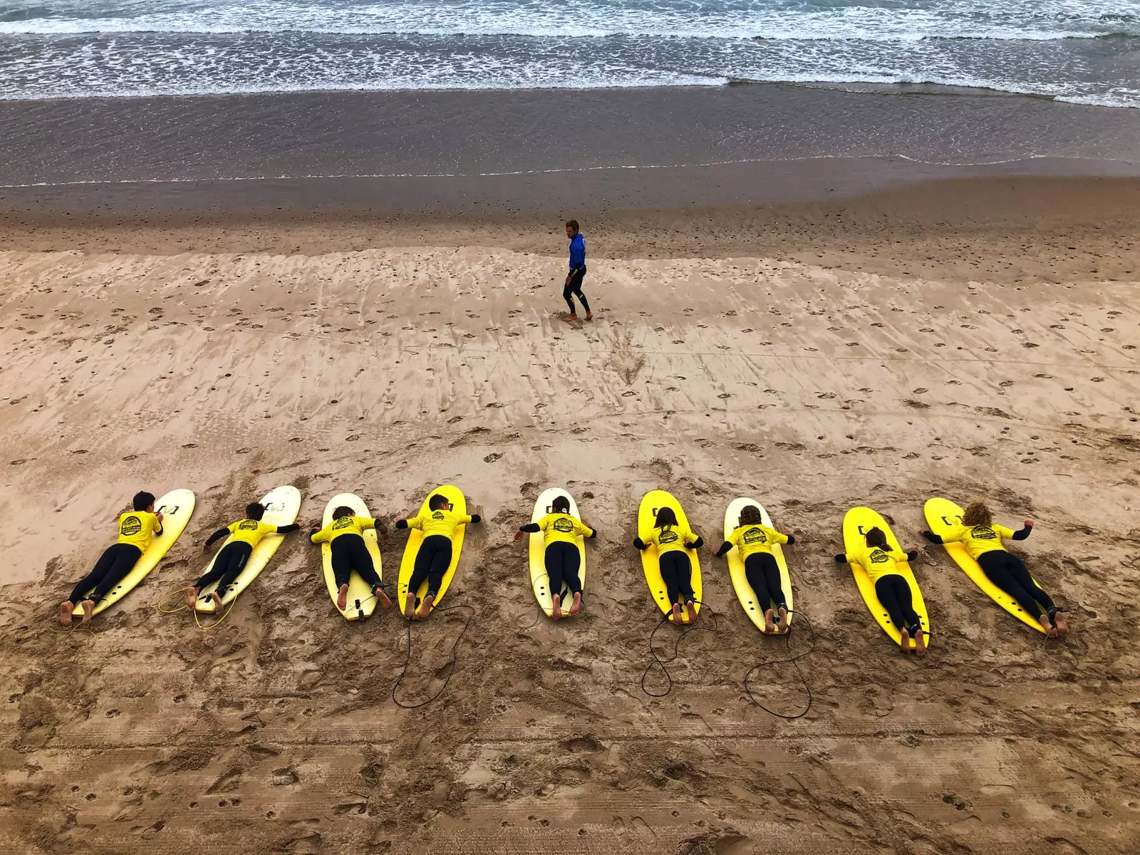 Children learning to surf on the beach of Santa Marina Ribadesella.