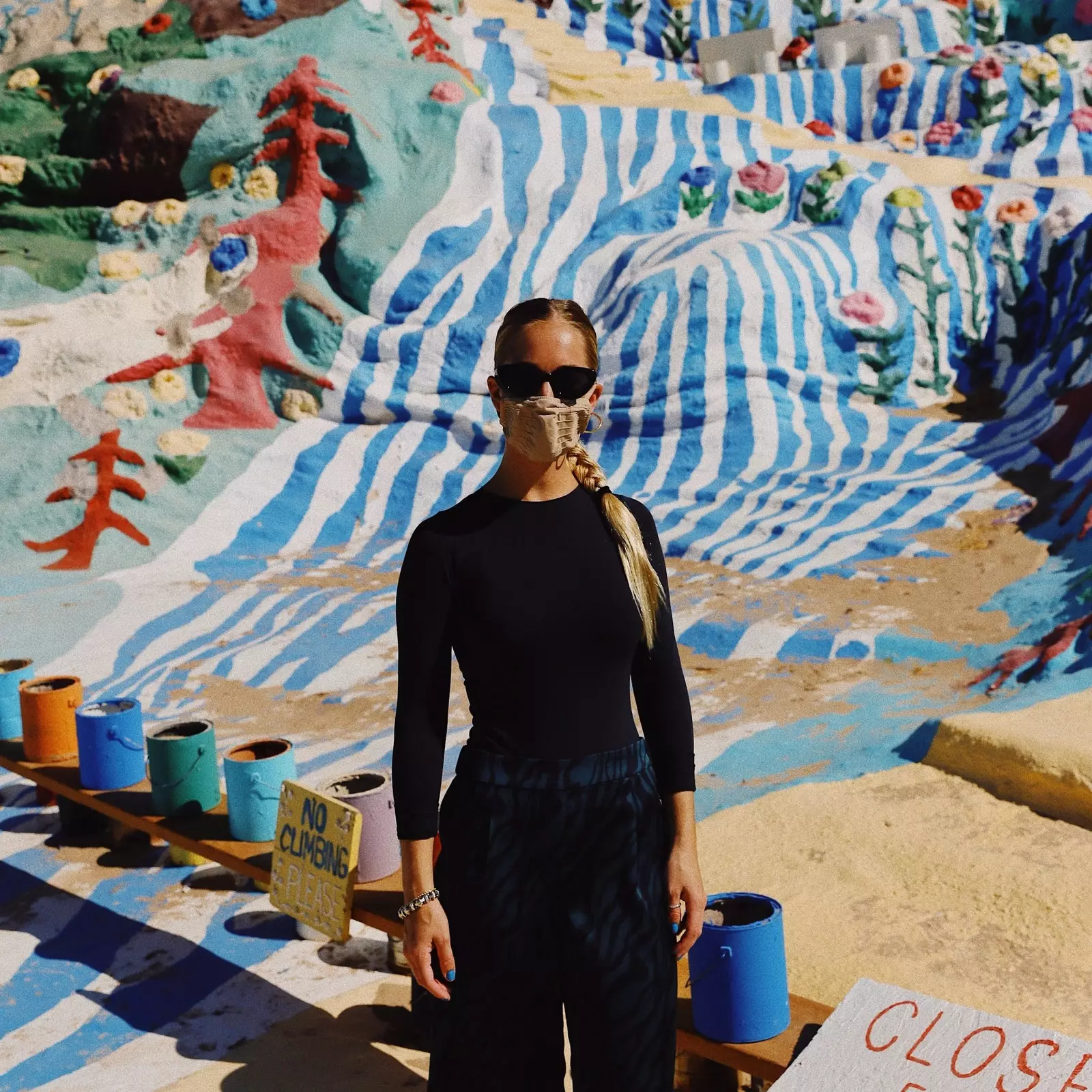 Žena cestovatel nosí masku na Salvation Mountain Spojené státy americké