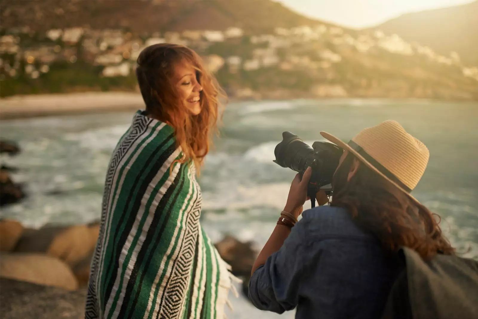 flicka som tar foto av en vän på stranden