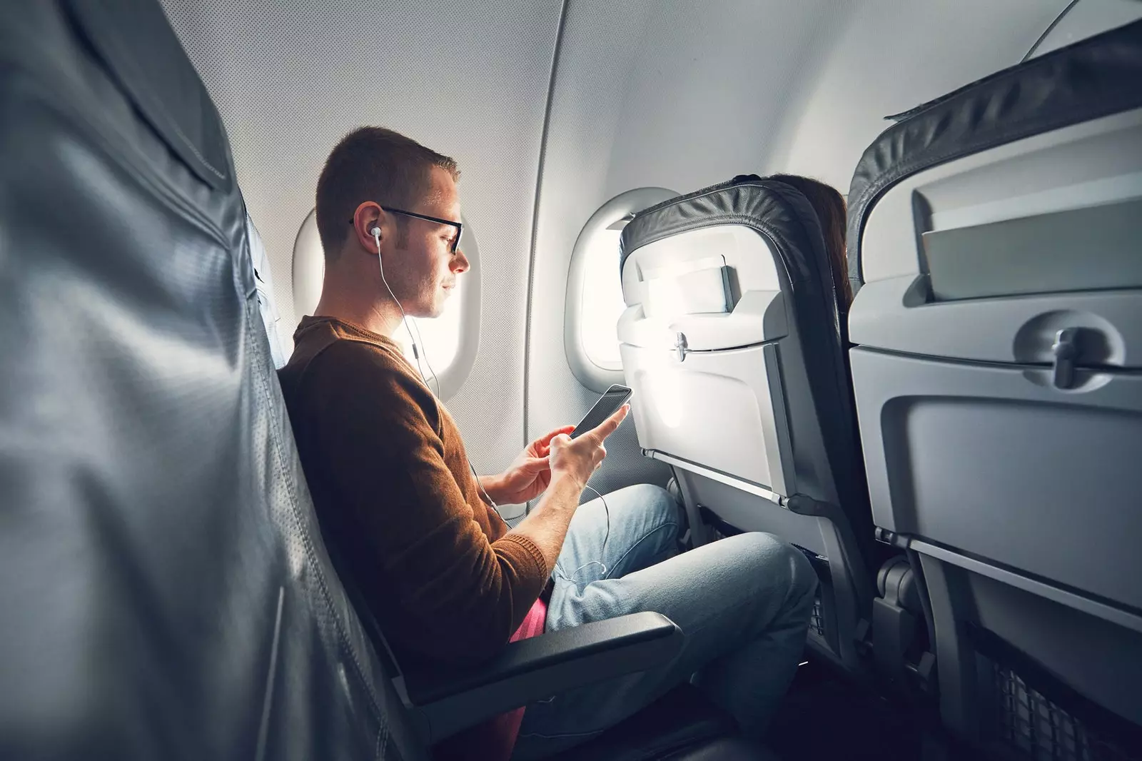 L'homme regarde votre mobile à l'intérieur d'un avion