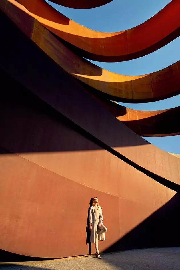 Carolina encostada nas paredes cor de ferrugem do Holon Design Museum por Ron Arad