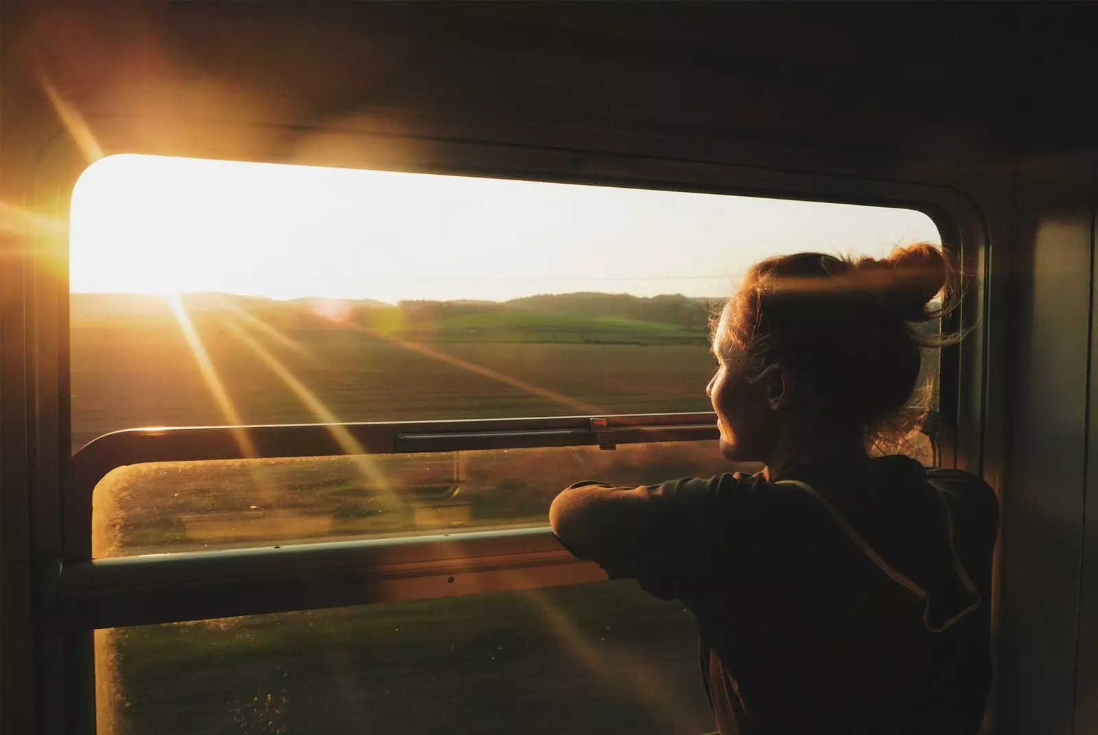 noia mirant per la finestra amb tren