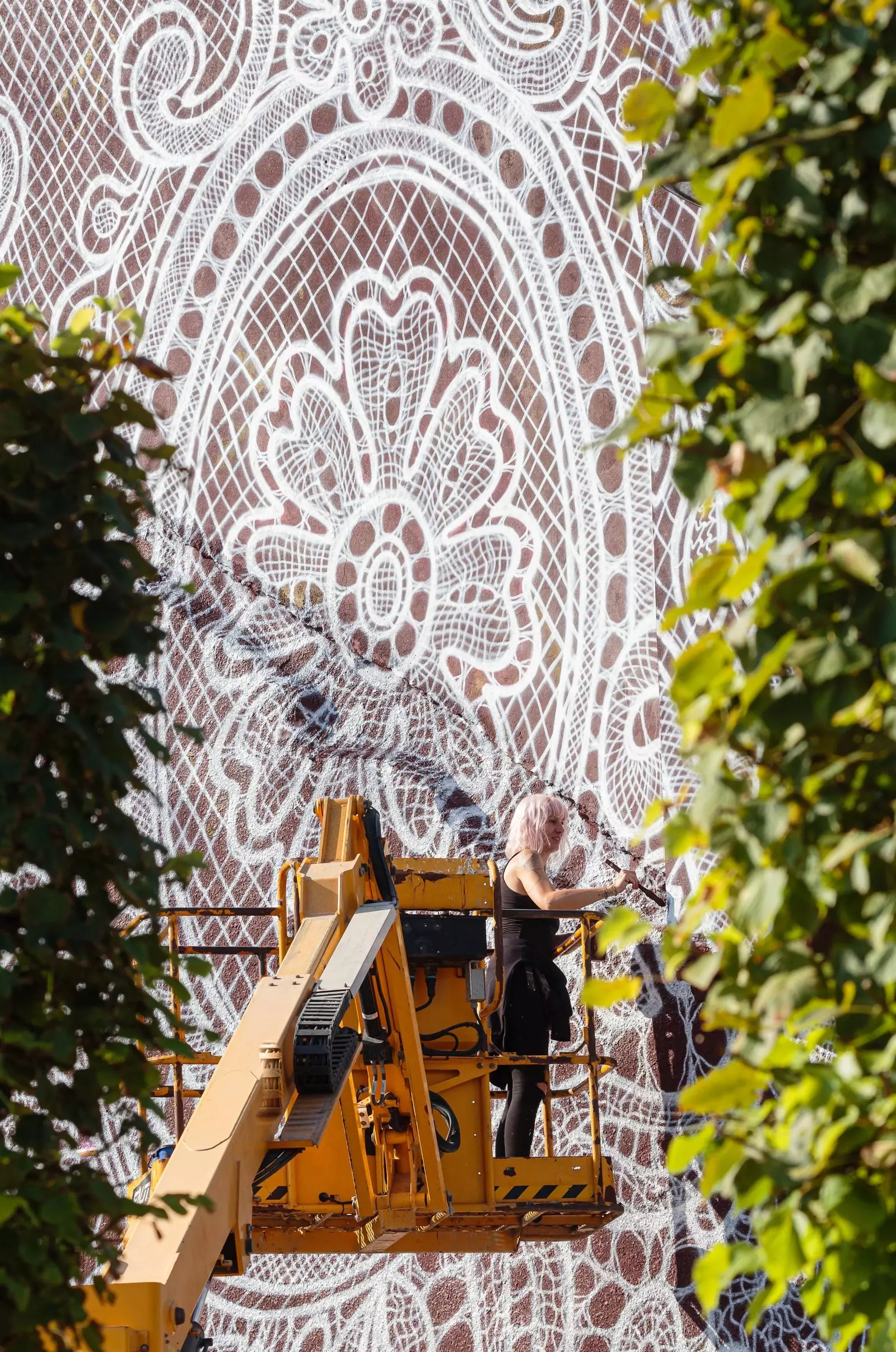 NeSpoon tijdens het schilderen van de muurschildering voor het Calais Street Art Festival.