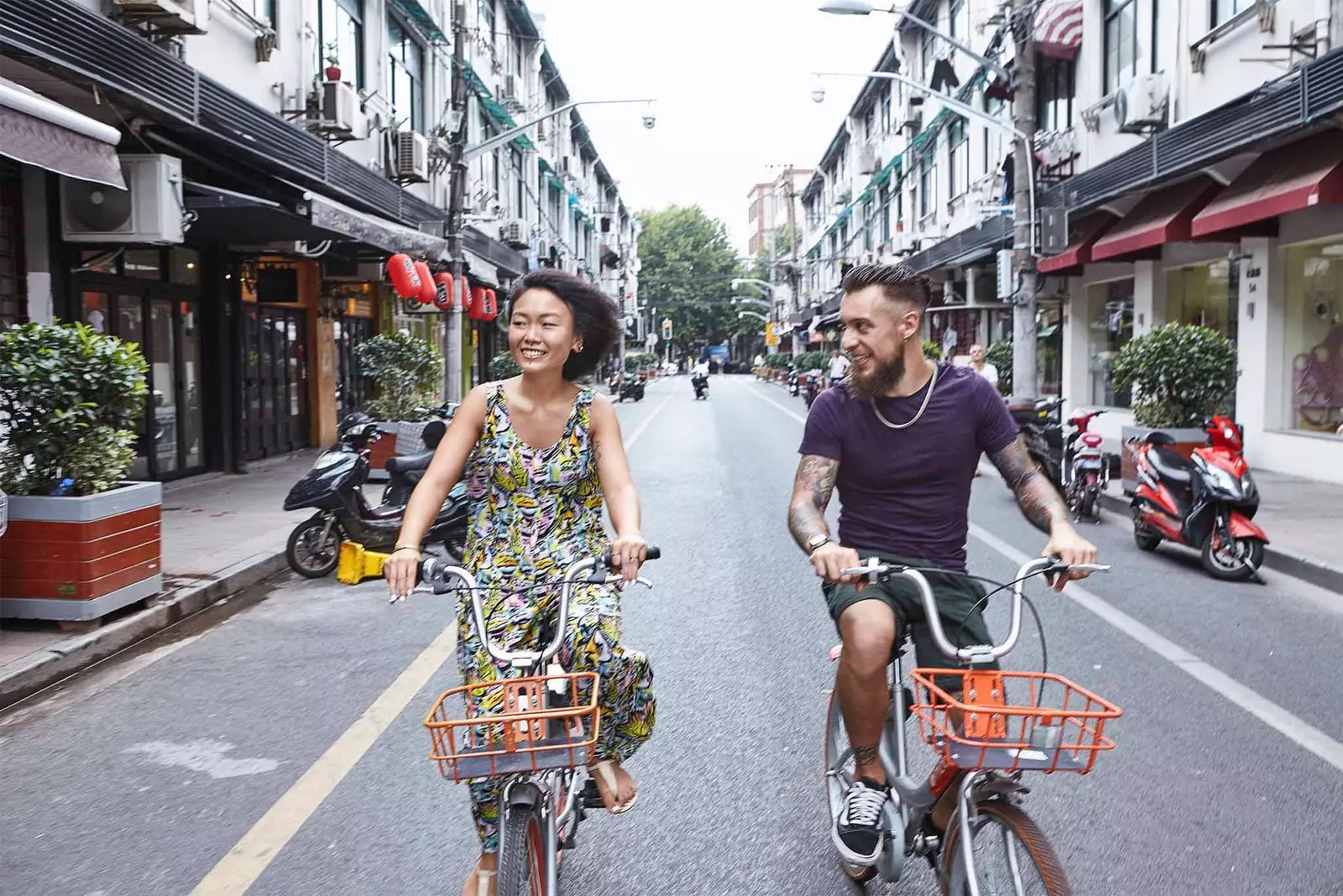 coppia multirazziale in bicicletta attraverso shanghai