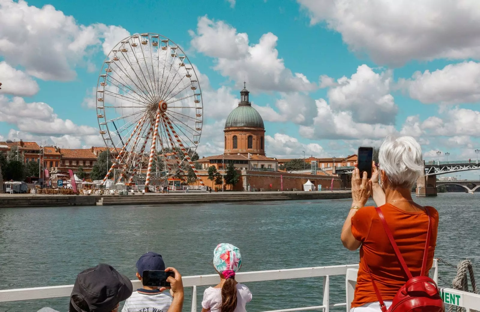 Famille photographiant une grande roue à Toulouse