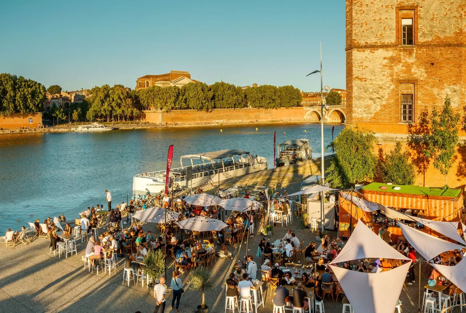 Líonann na ‘guingettes’ sráideanna Toulouse leis an saol i rith an tsamhraidh