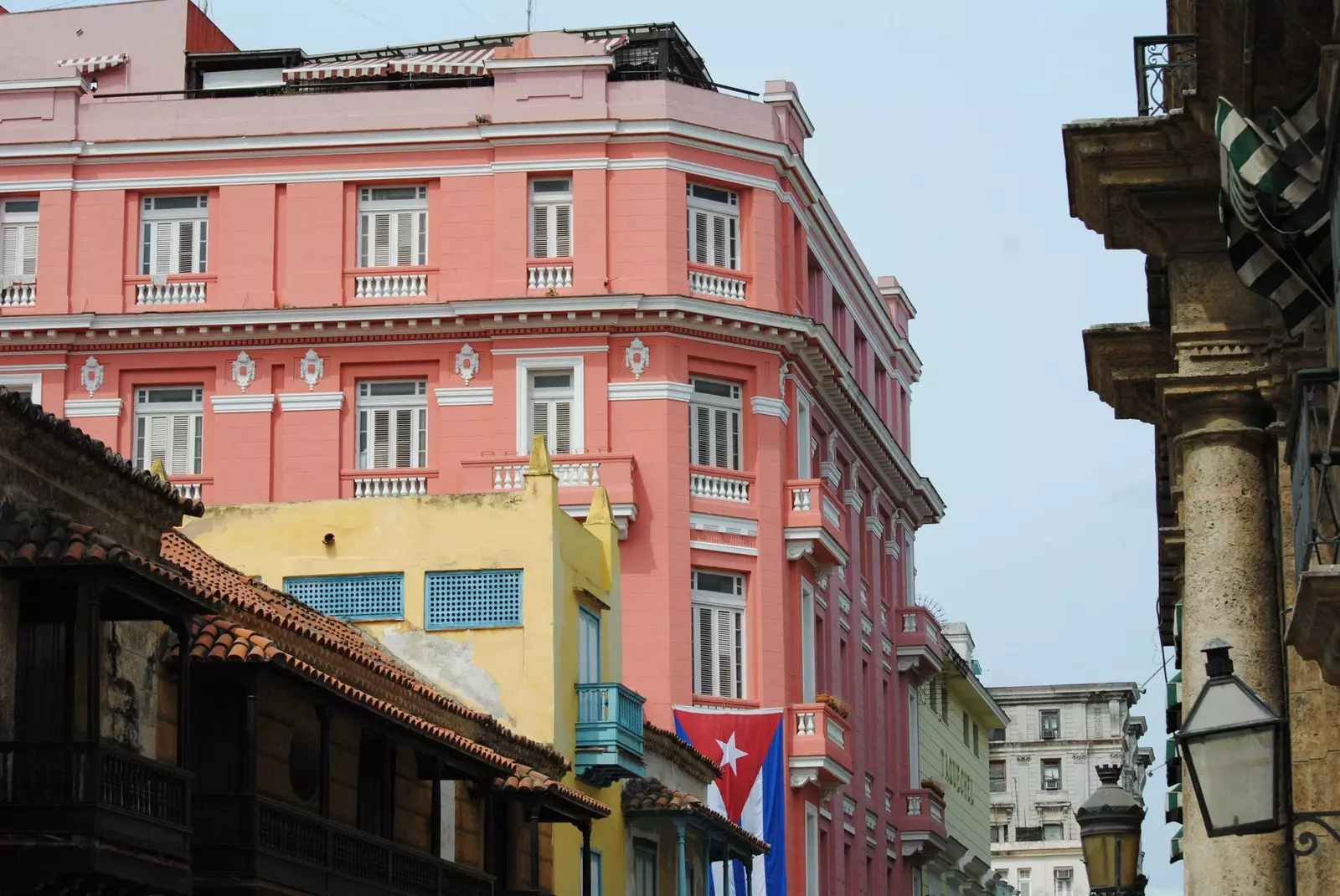 Muka bangunan merah jambu hotel Ambos Mundos dan barang kemas La Muñequita Azul di Old Havana.