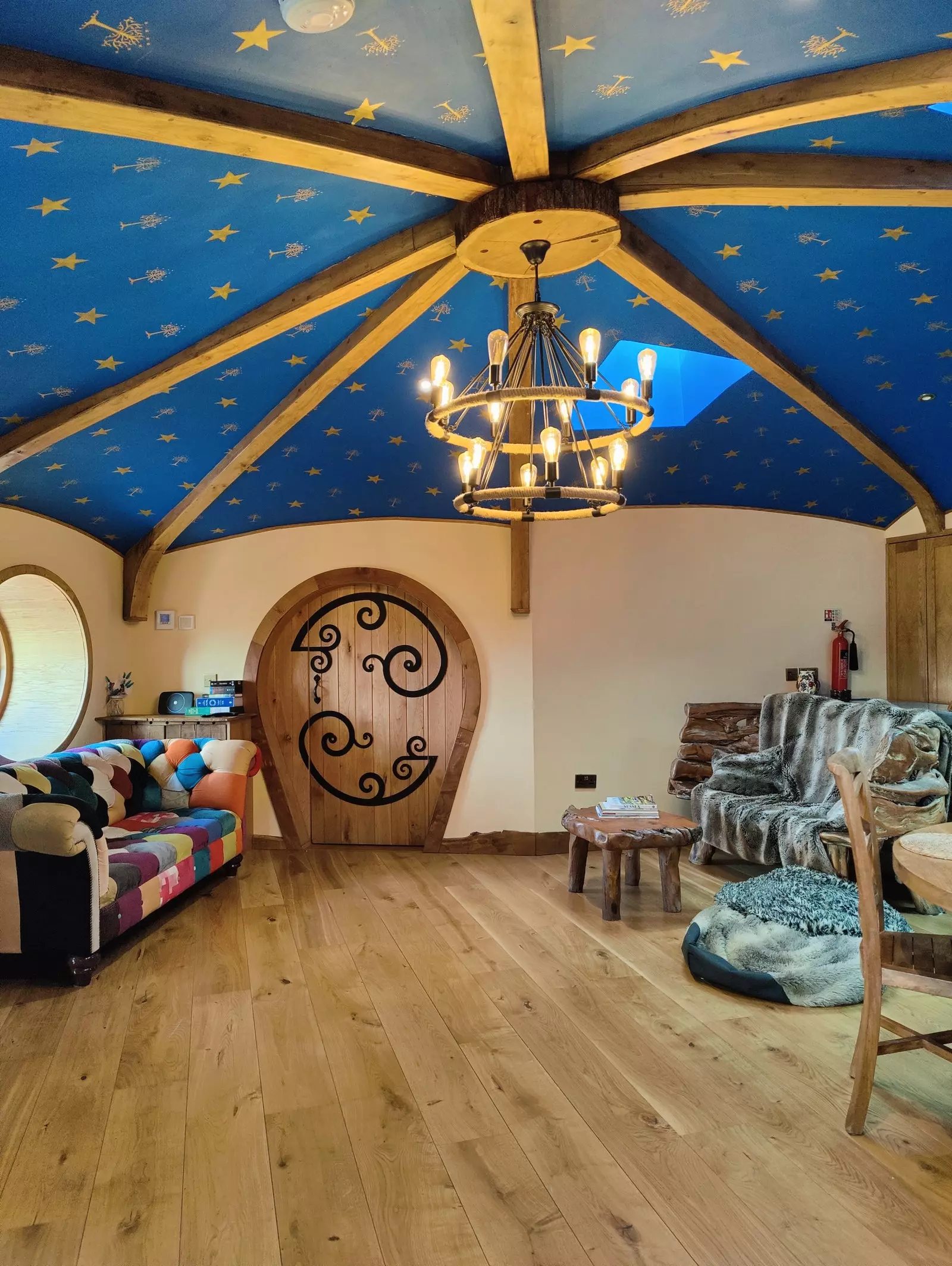 The living room boasts a blue dome ceiling with stars, bowed doors, comfortable sofas and a hanging ceiling light.