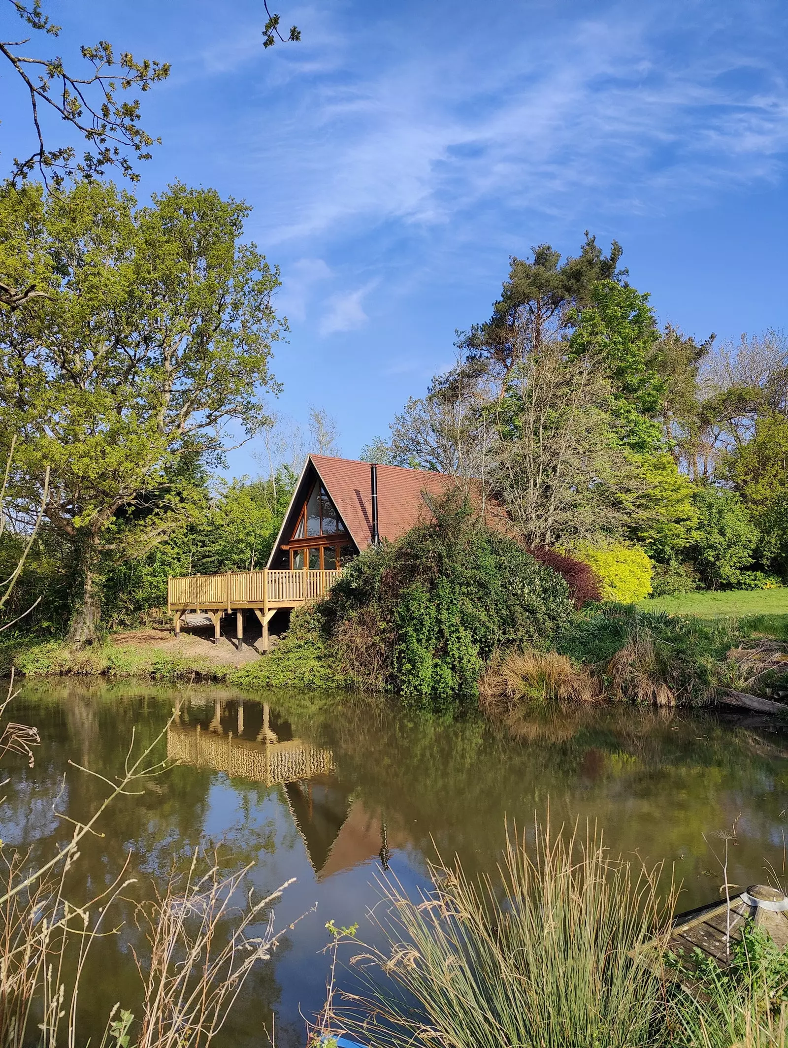 Pronë Avalon House në një vresht me pamje nga një pellg natyror.