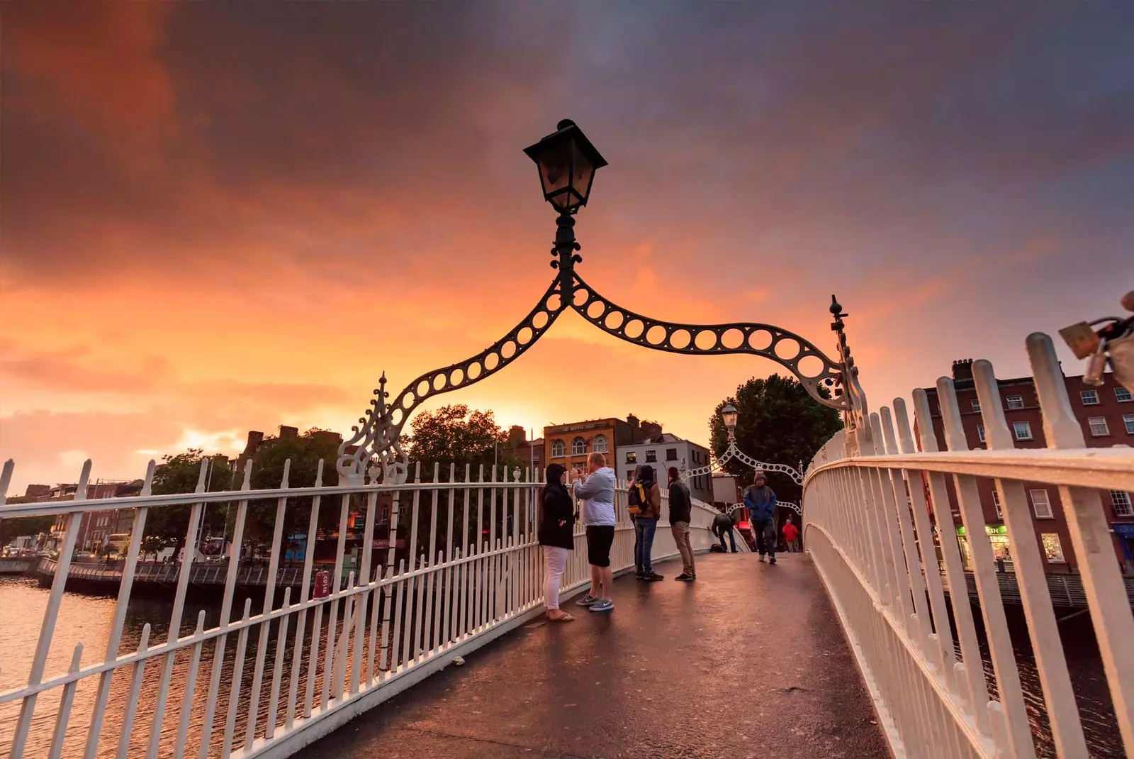 orang-orang berjalan melintasi Half Penny Bridge Dublin