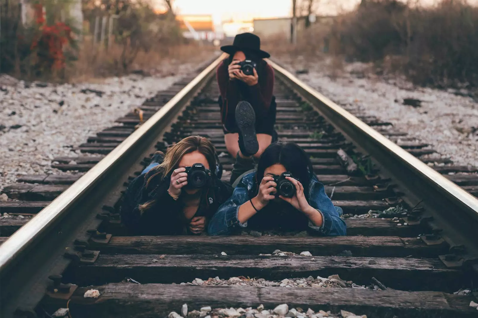 tren yolunda kamerayla fotoğraf çeken kızlar