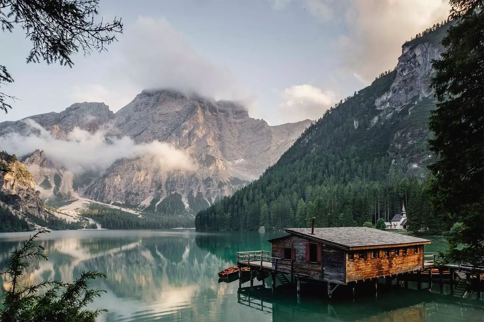 cabană pe un lac cu un munte în spate