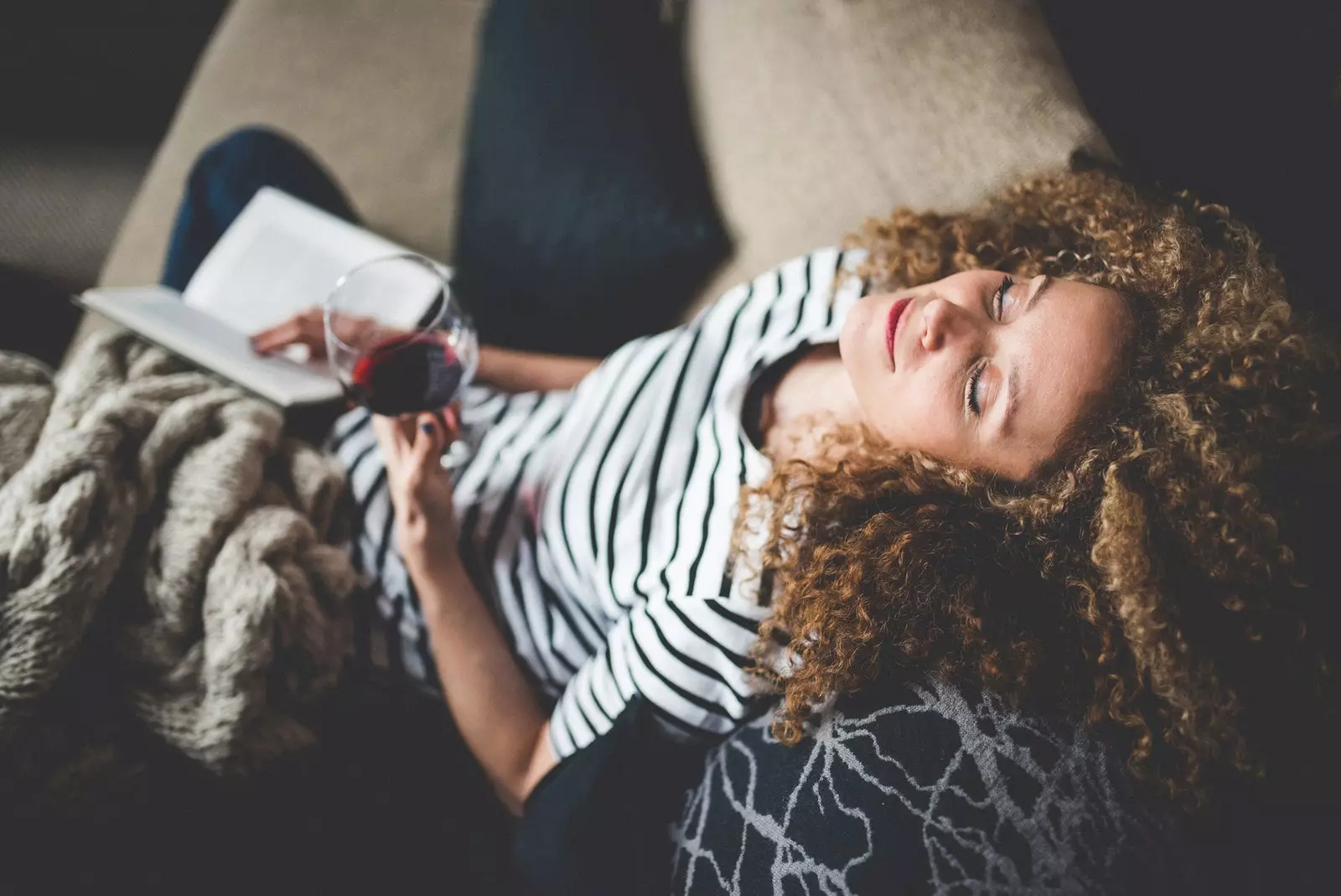 Kvinna som läser med ett glas vin