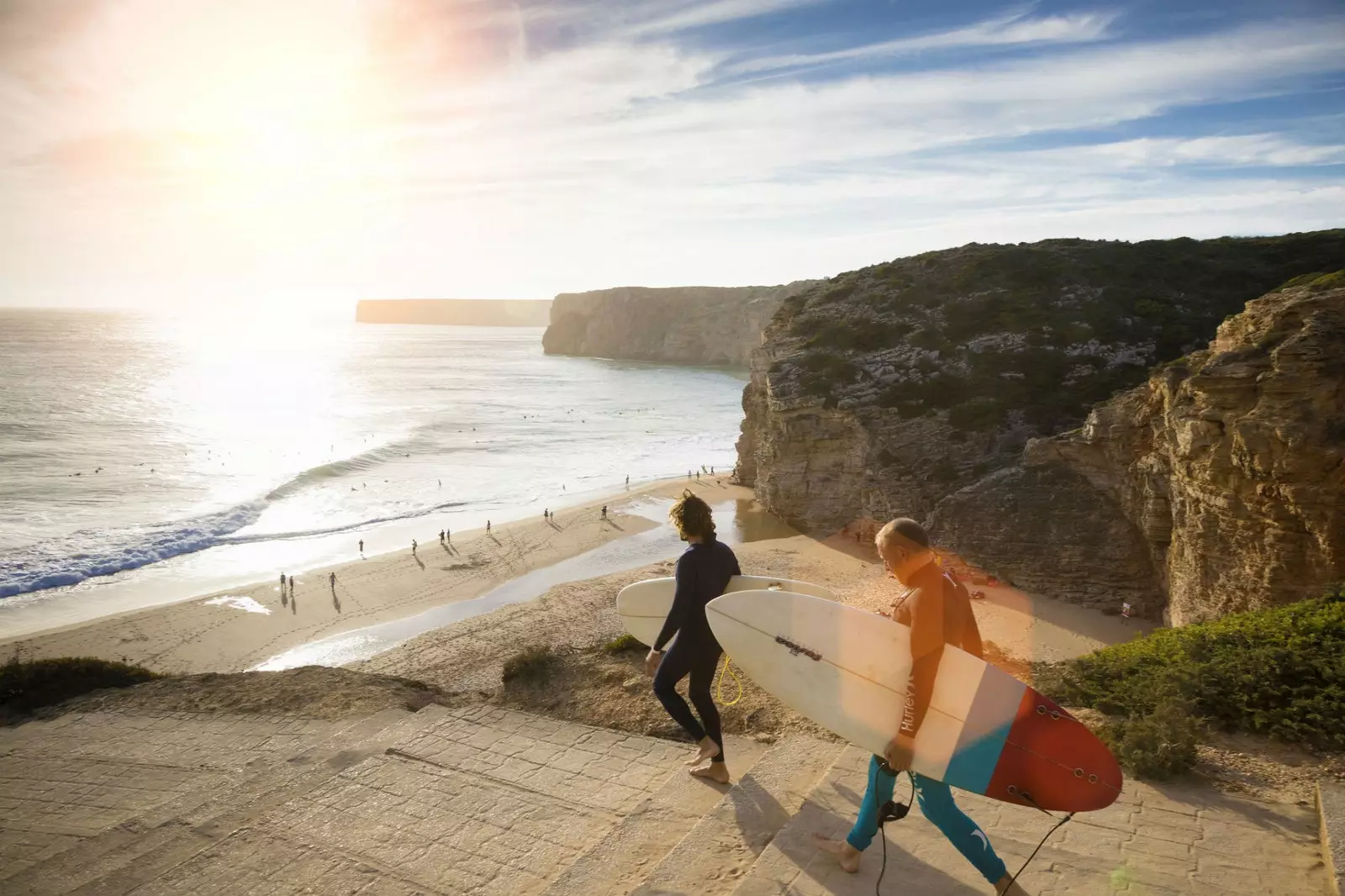 Des surfeurs descendant vers la plage de Beliche à Sagres.