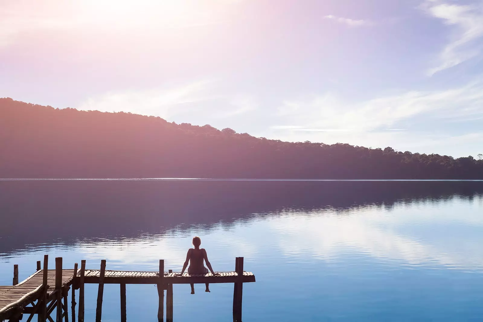 Donna seduta davanti a un lago