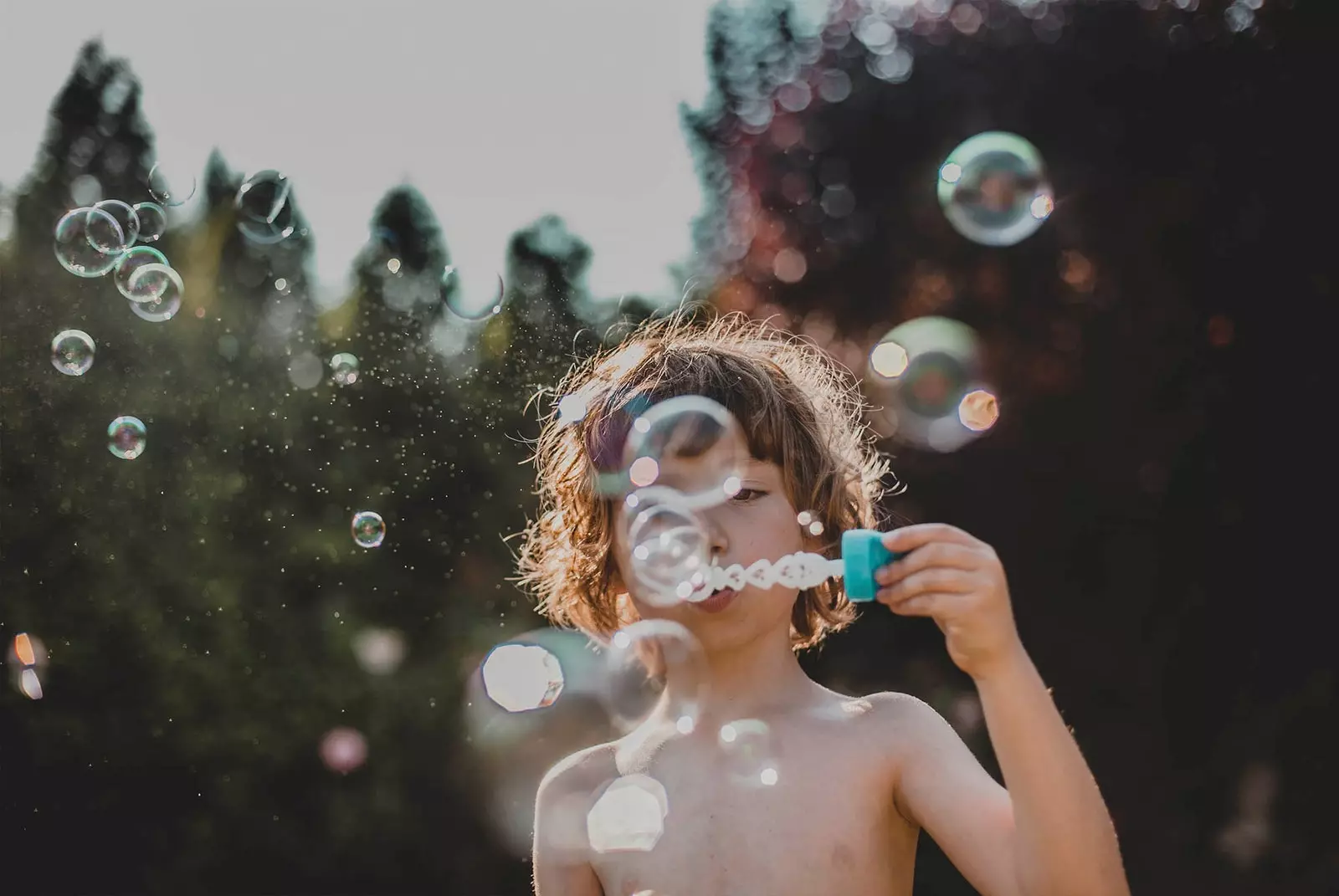 enfant soufflant des bulles de savon