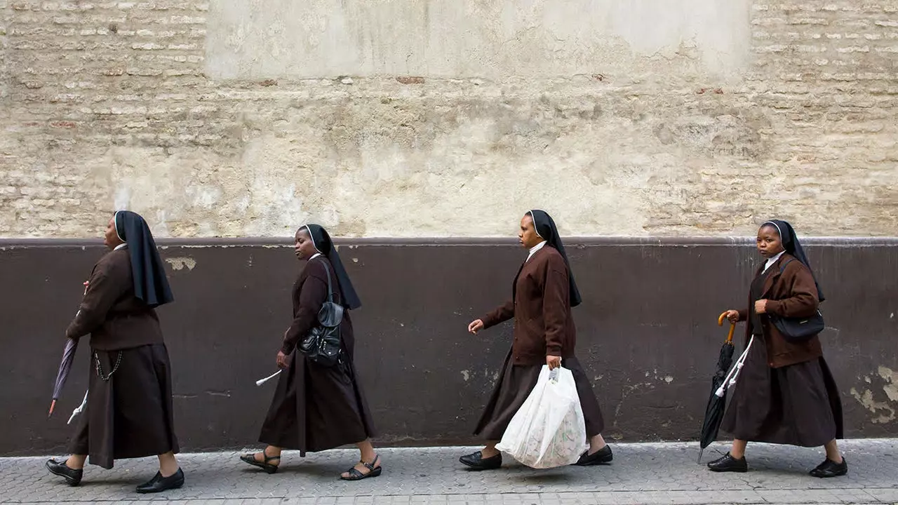 An t-ealaíontóir a thógann grianghraif de na 'Paseantes' as Seville