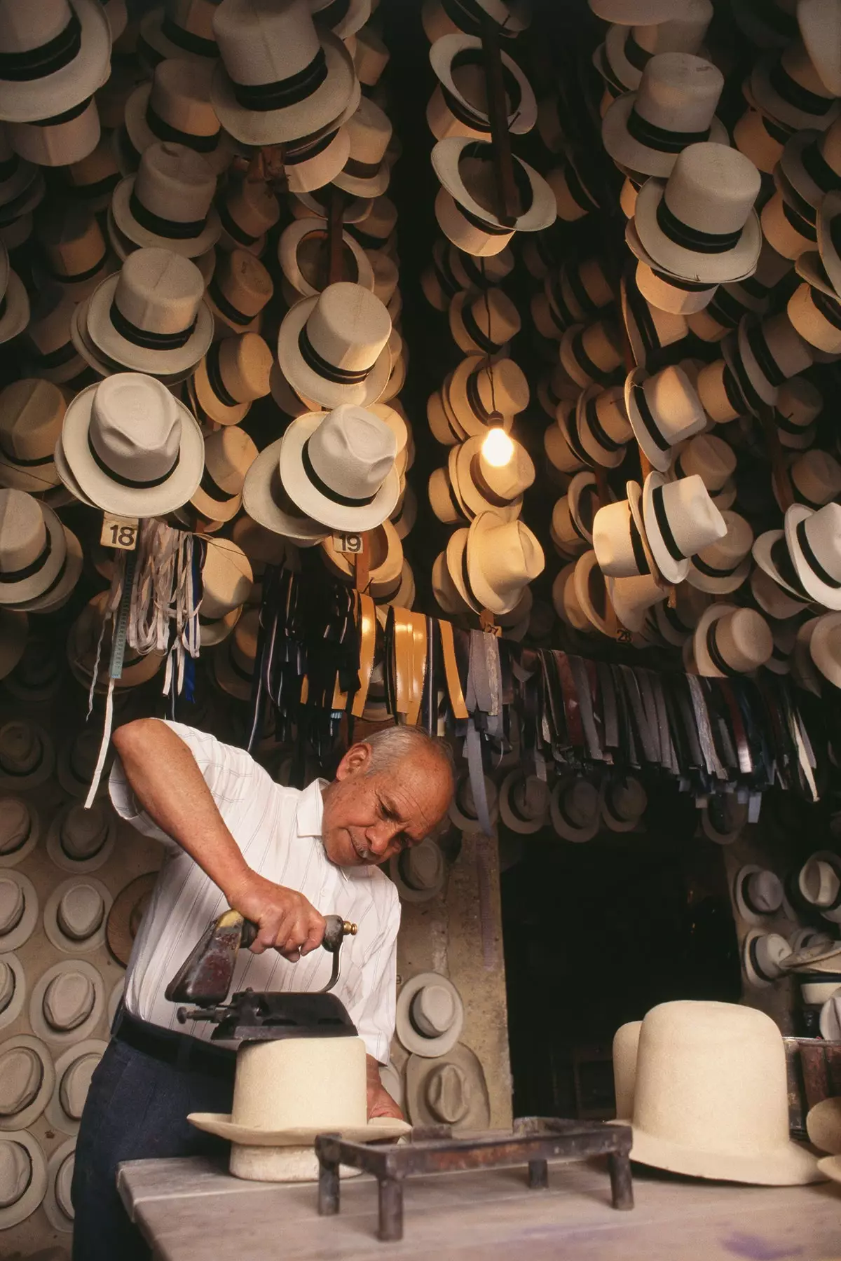 An artisan works on a toquilla straw hat in the city of Cuenca Ecuador.