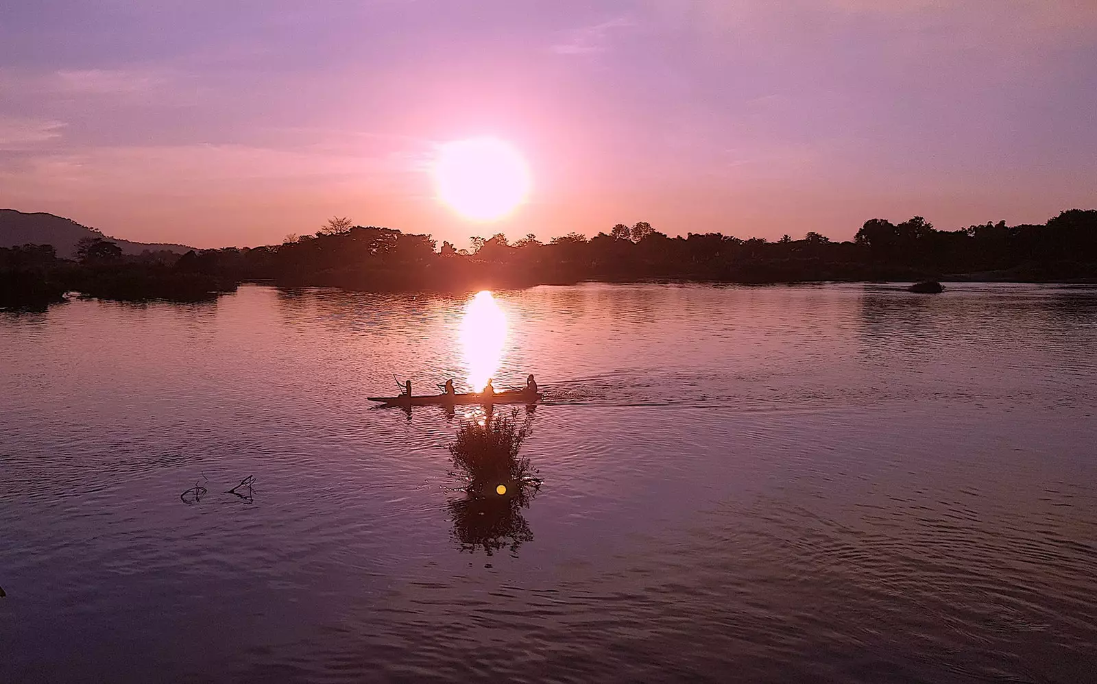 Vaaleanpunainen auringonlasku Mekong-joella