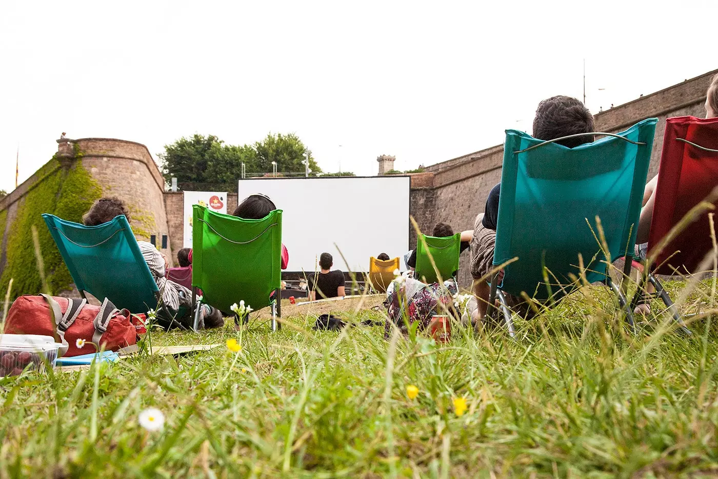 Nies mimduda fuq il-lawn ta 'Sala Montjuïc fiċ-ċinema tas-sajf