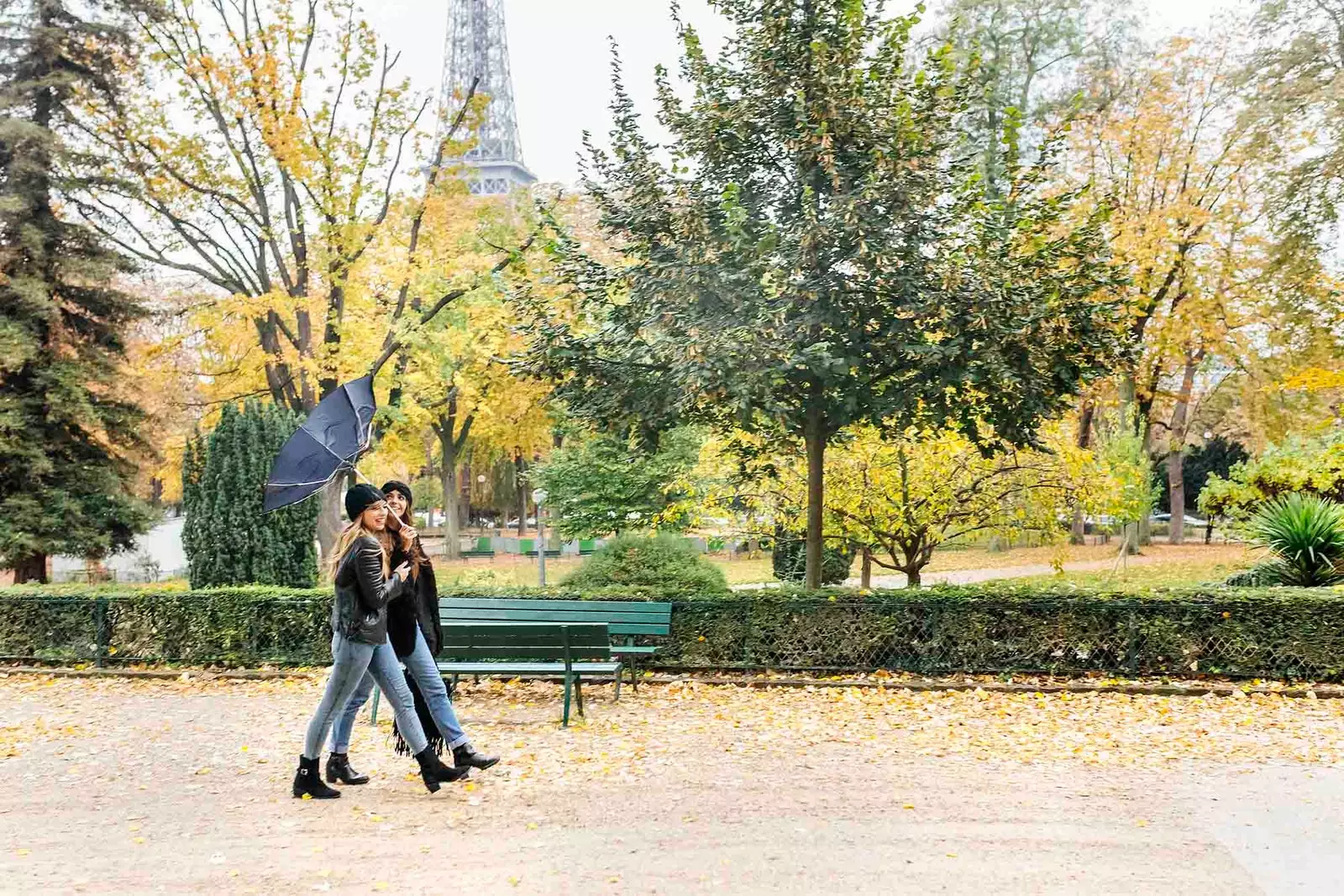 due ragazze che camminano per Parigi con l'ombrello rotto