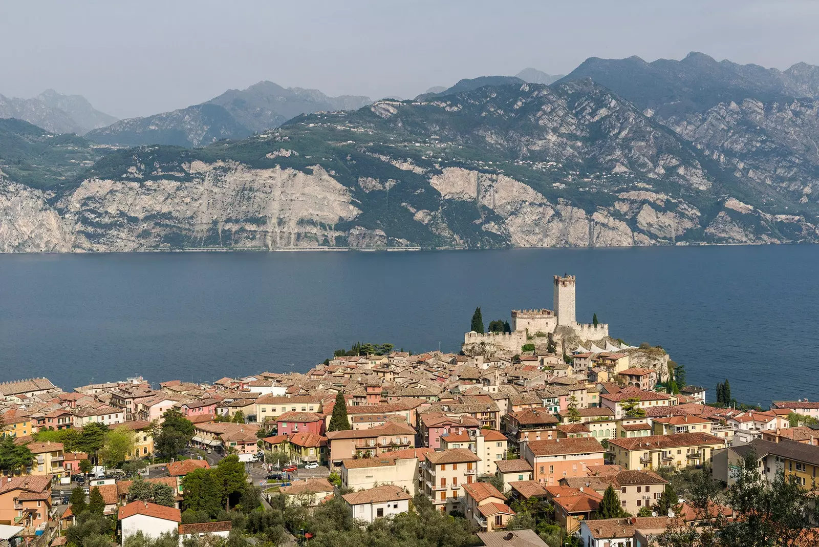 Maoni ya angani ya Lago di Garda iliyozungukwa na miteremko ya mawe na vijiji vyema na vya kupendeza.