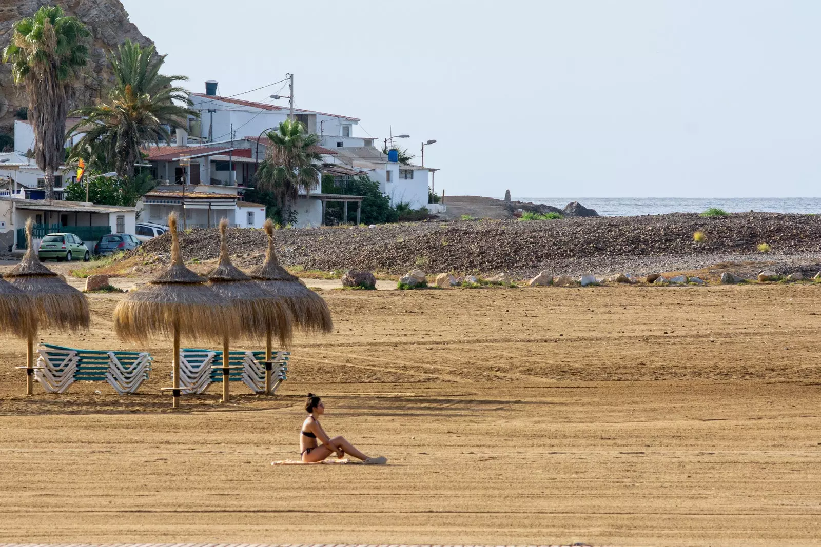 Msichana akiota jua kwenye ufuo wa jangwani huko Puerto de Mazarrón huko Murcia