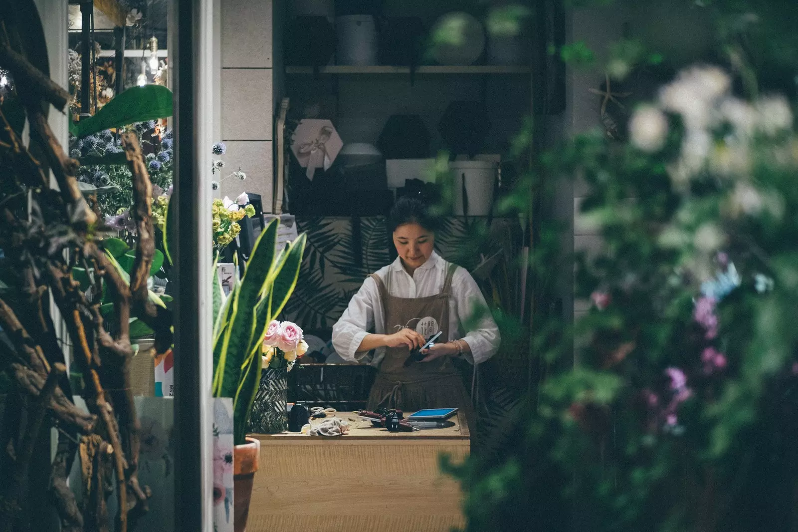 Blomsterhandler arbejder i en blomsterbutik