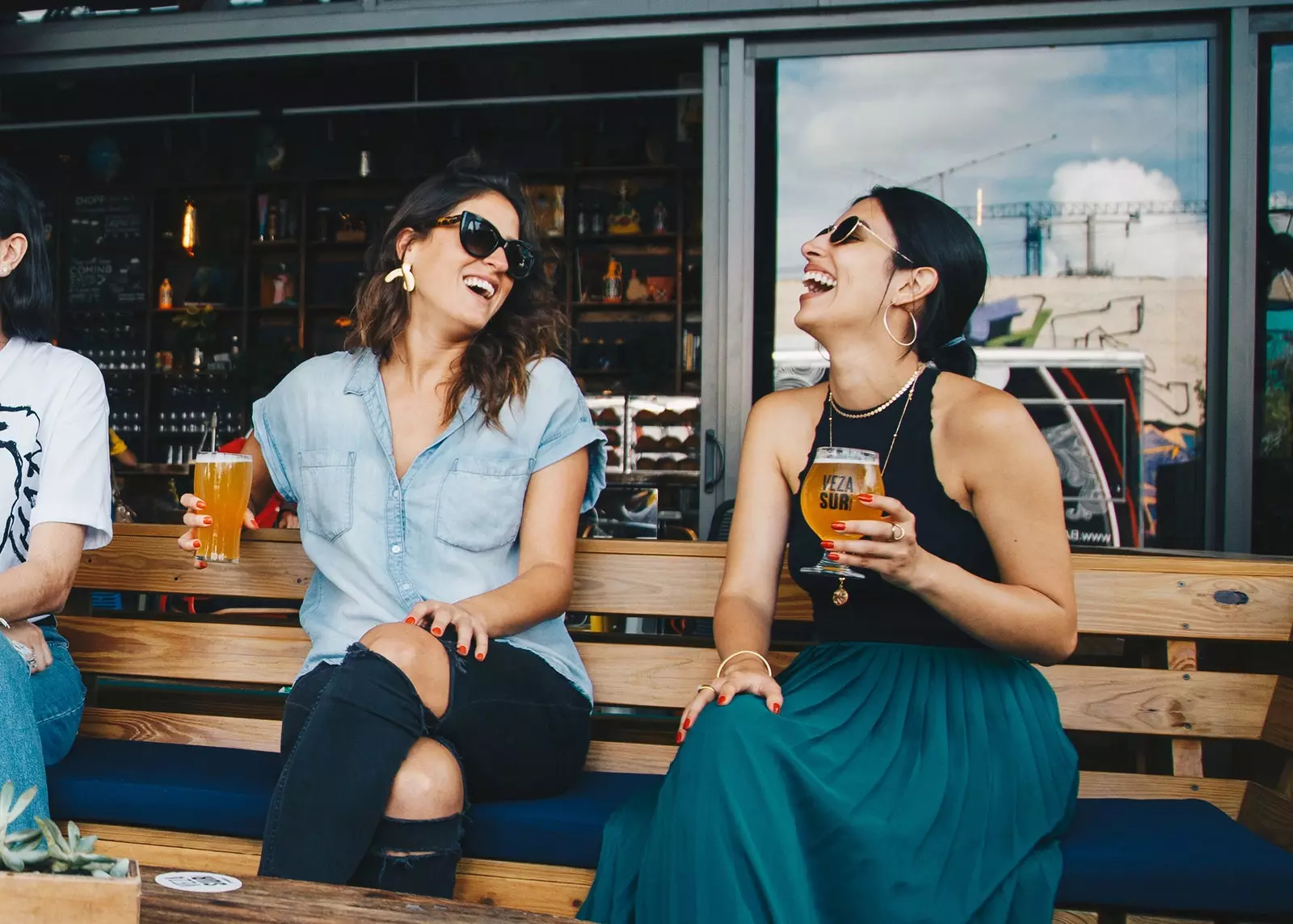 Duas mulheres tomam uma cerveja no terraço de um bar