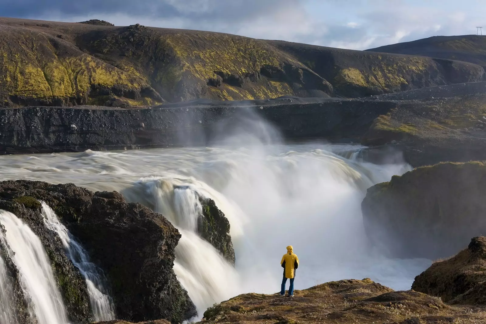 Seorang lelaki melihat air terjun Dynkur di Iceland.