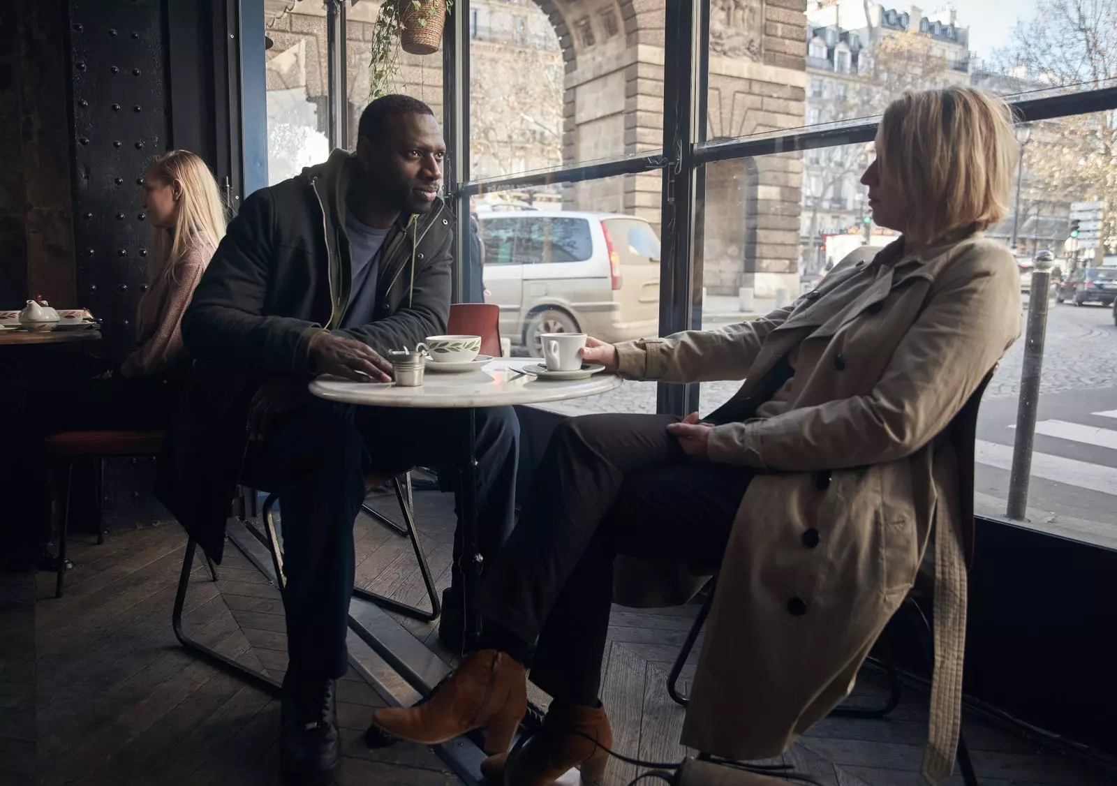 Assane och Claire på en restaurang med utsikt över Porte de Saint Martin.