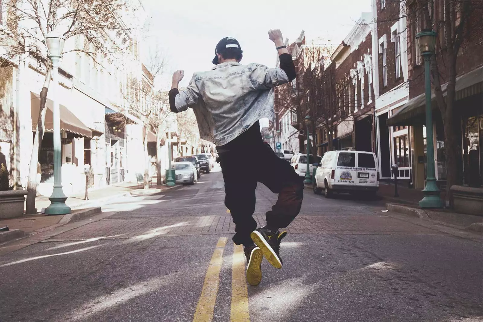 boy jumping on his back on a street