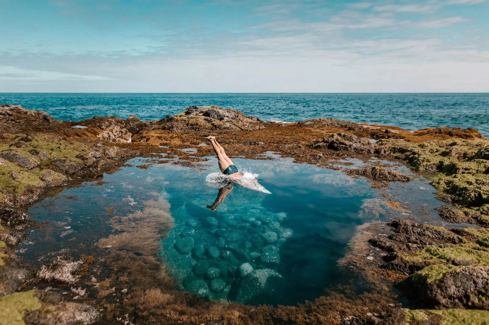 Homme se plongeant dans une piscine naturelle dans les îles Canaries