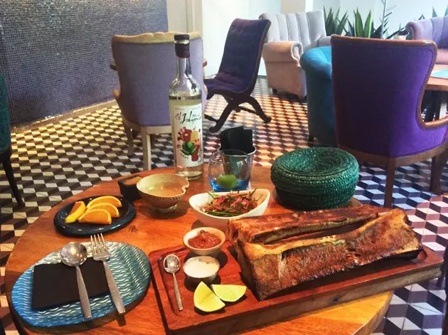 Jícara d'un mezcal fumé accompagnant une moelle grillée fumante.