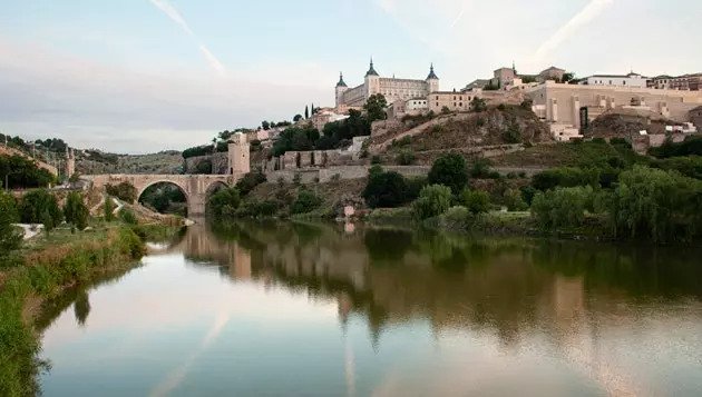 Alcntara ko'prigi ostidagi Tagus daryosi va fonda Alczar