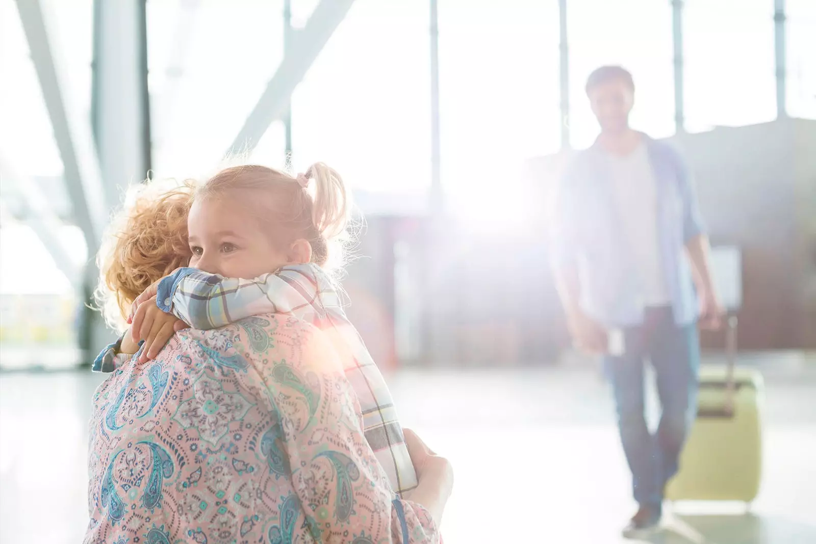 mother hugging daughter airport