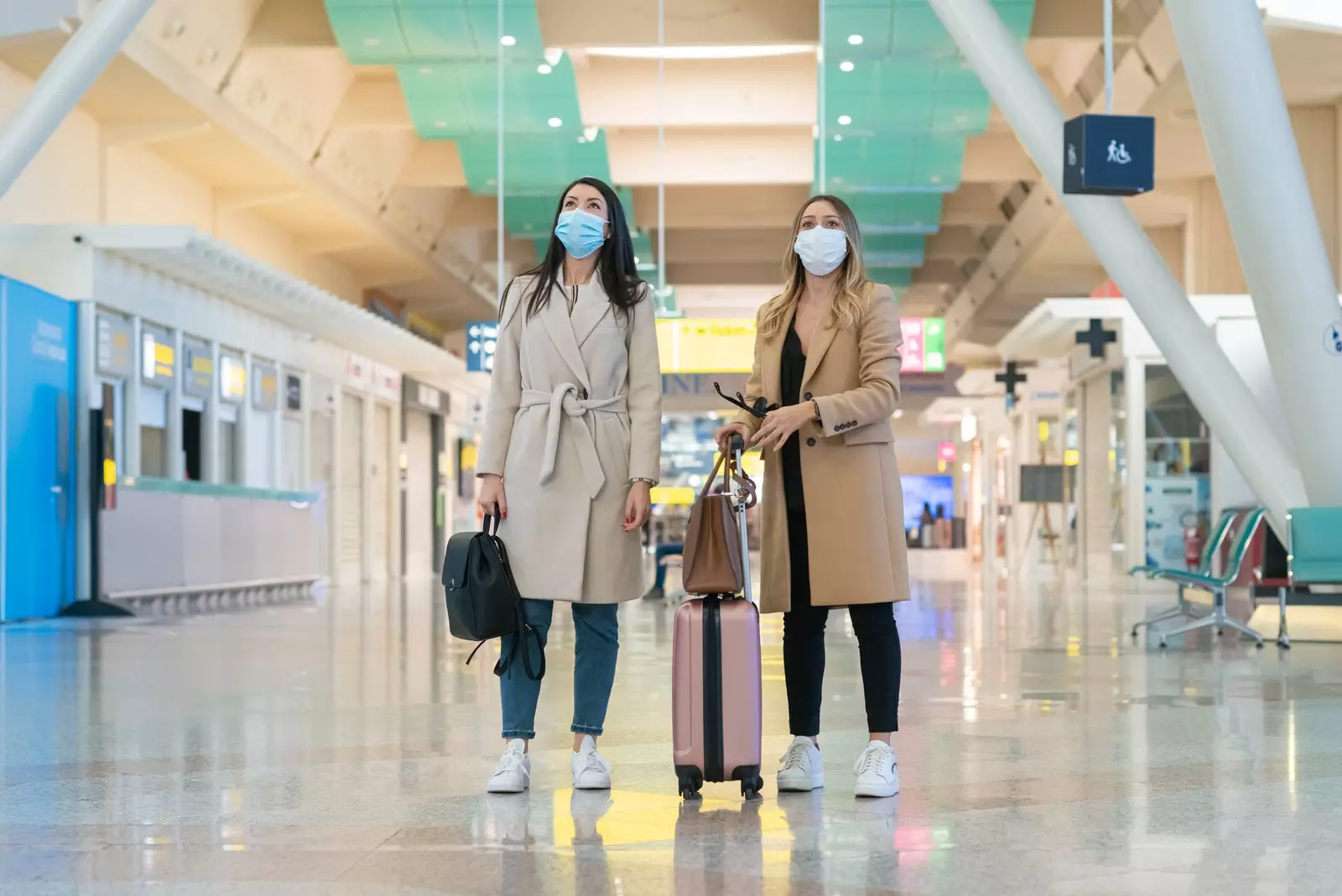 Donne in aeroporto con maschera