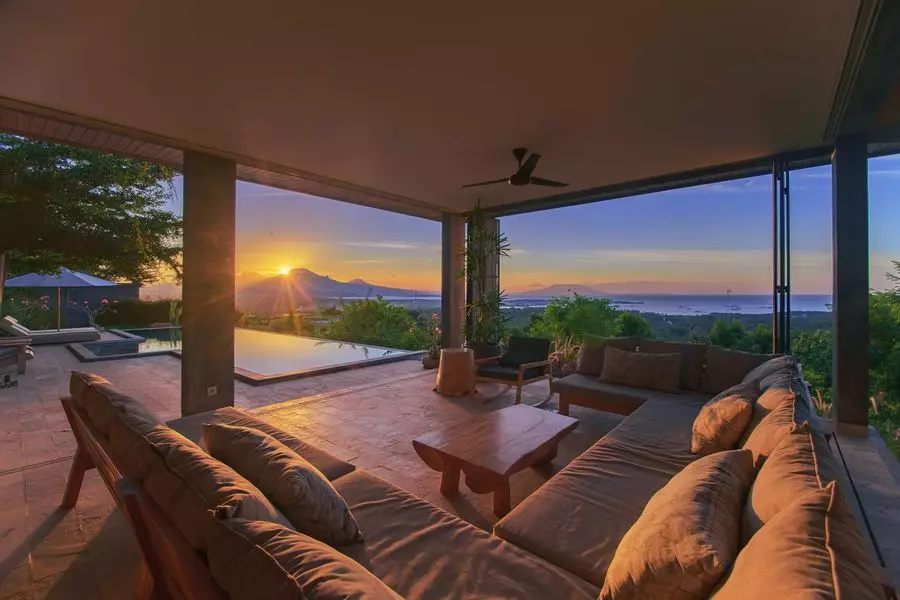 Solnedgang på Bali set fra den luksuriøse udendørs stue i et af husene, der er tilgængelige i 'HomeExchange Collection'.