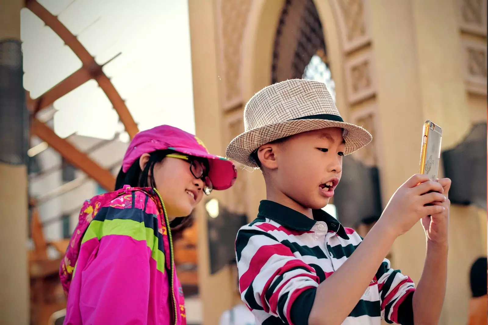 anak laki-laki bermain dengan ponsel dan anak perempuan menatapnya