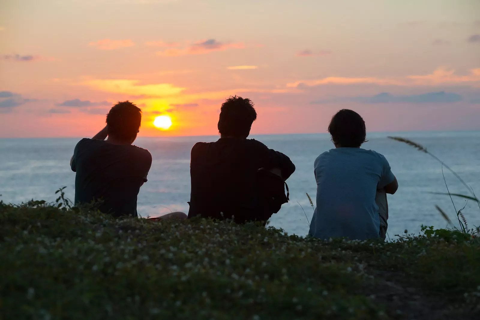 Tre giovani uomini che guardano il tramonto