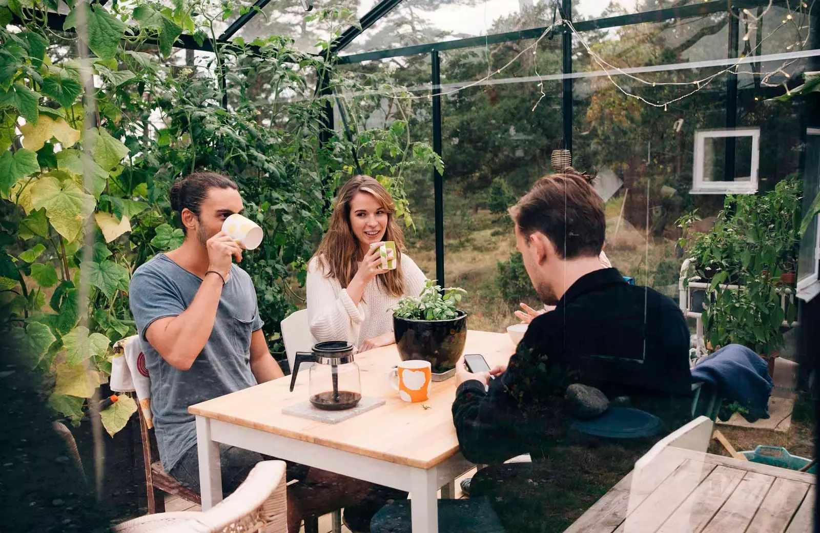 vrienden die koffie drinken in een kas