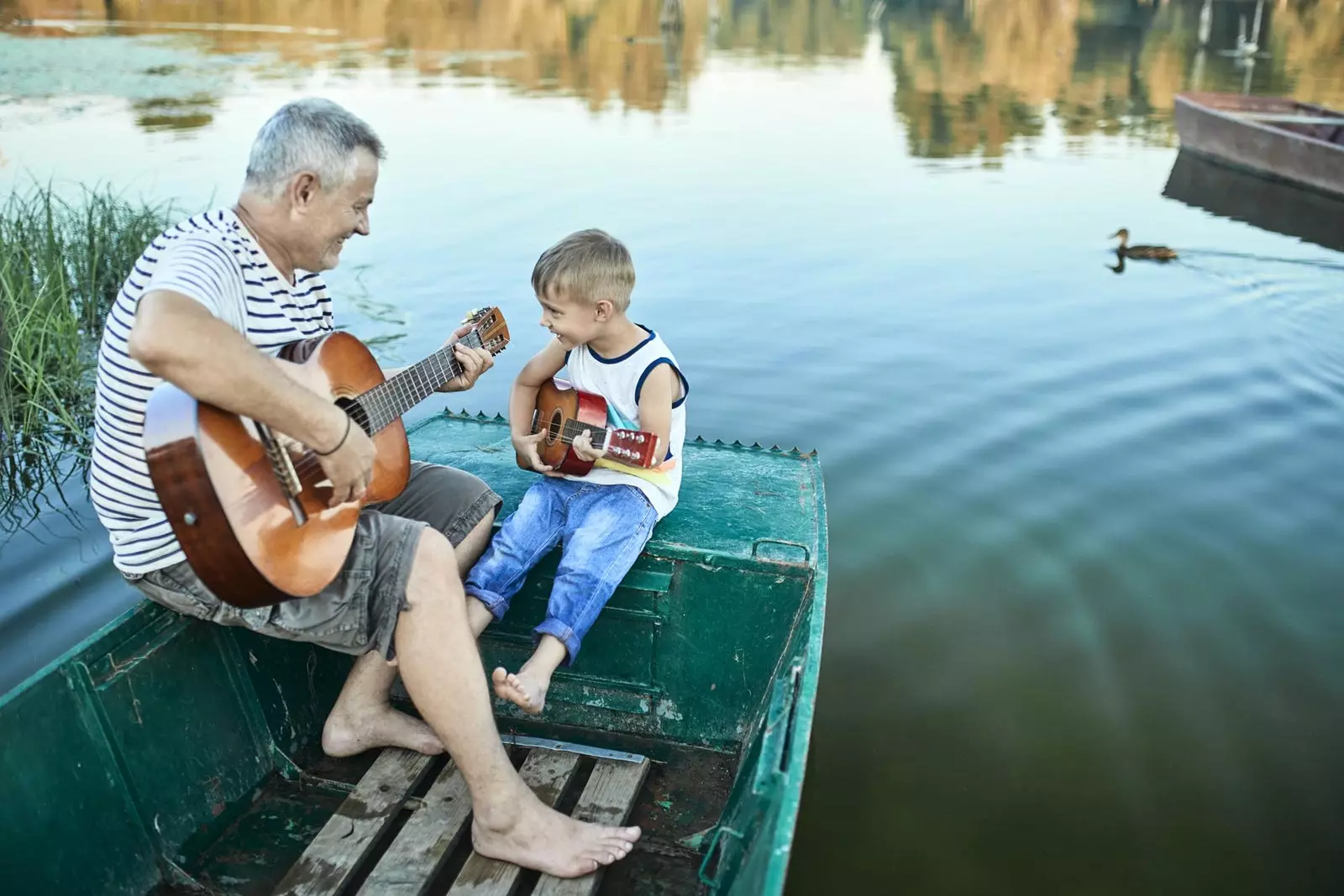 isoisä ja pojanpoika soittamassa kitaraa