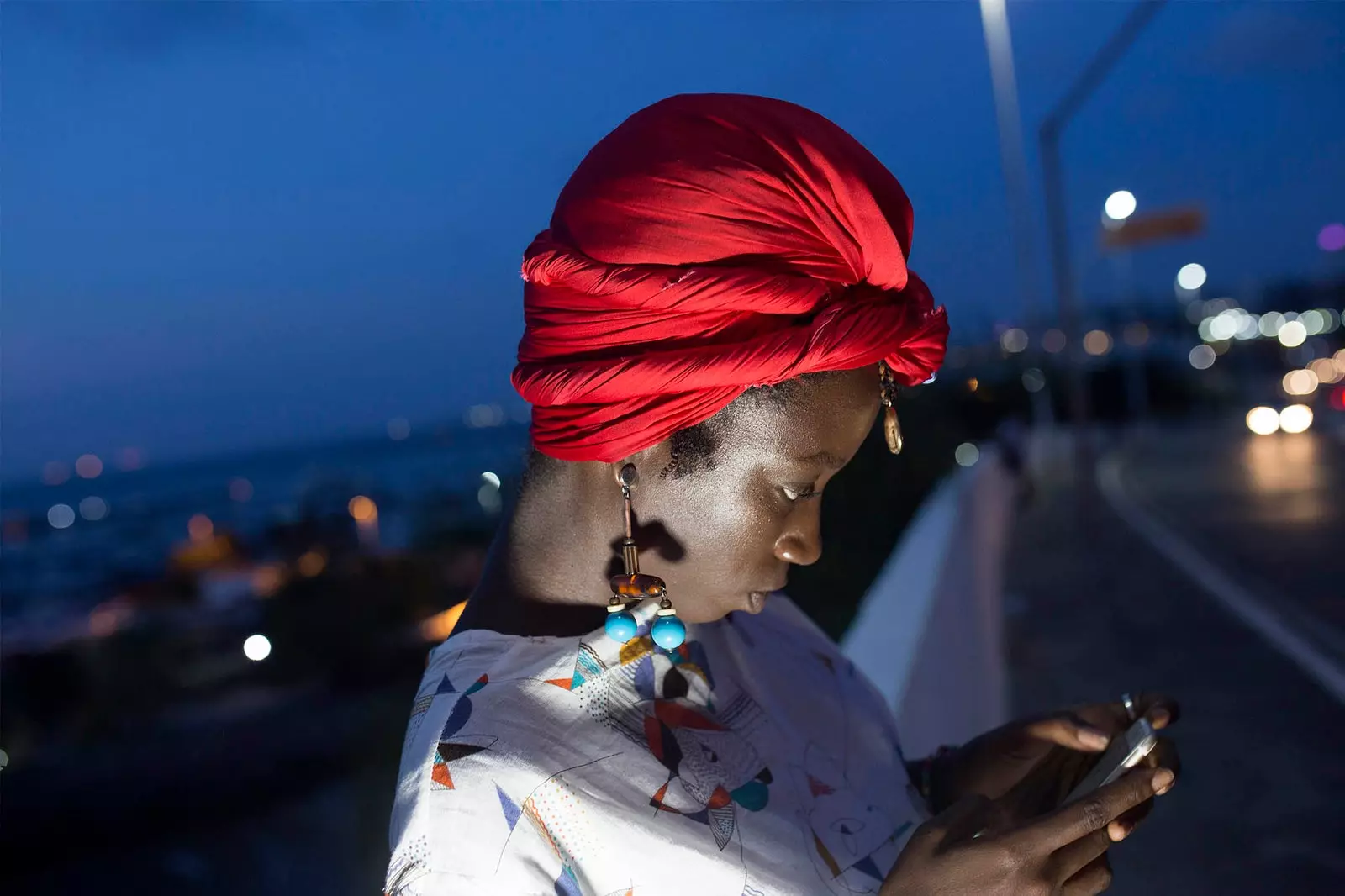 afrikansk kvinne ser på en mobil