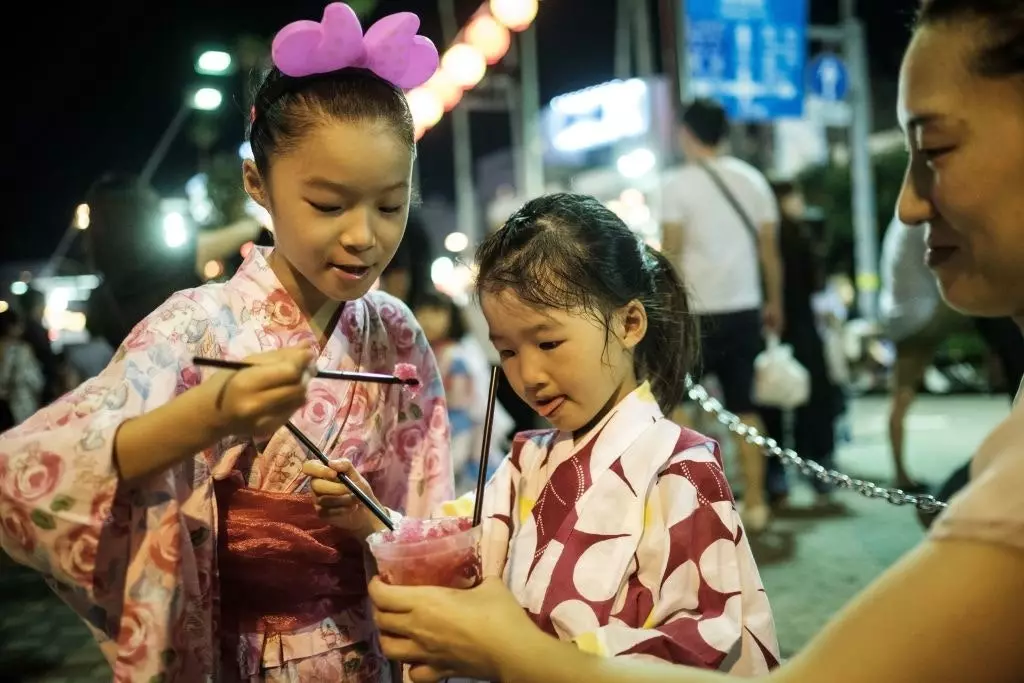 Mädchen trinken Kakigori während der Awa Odori-Feier