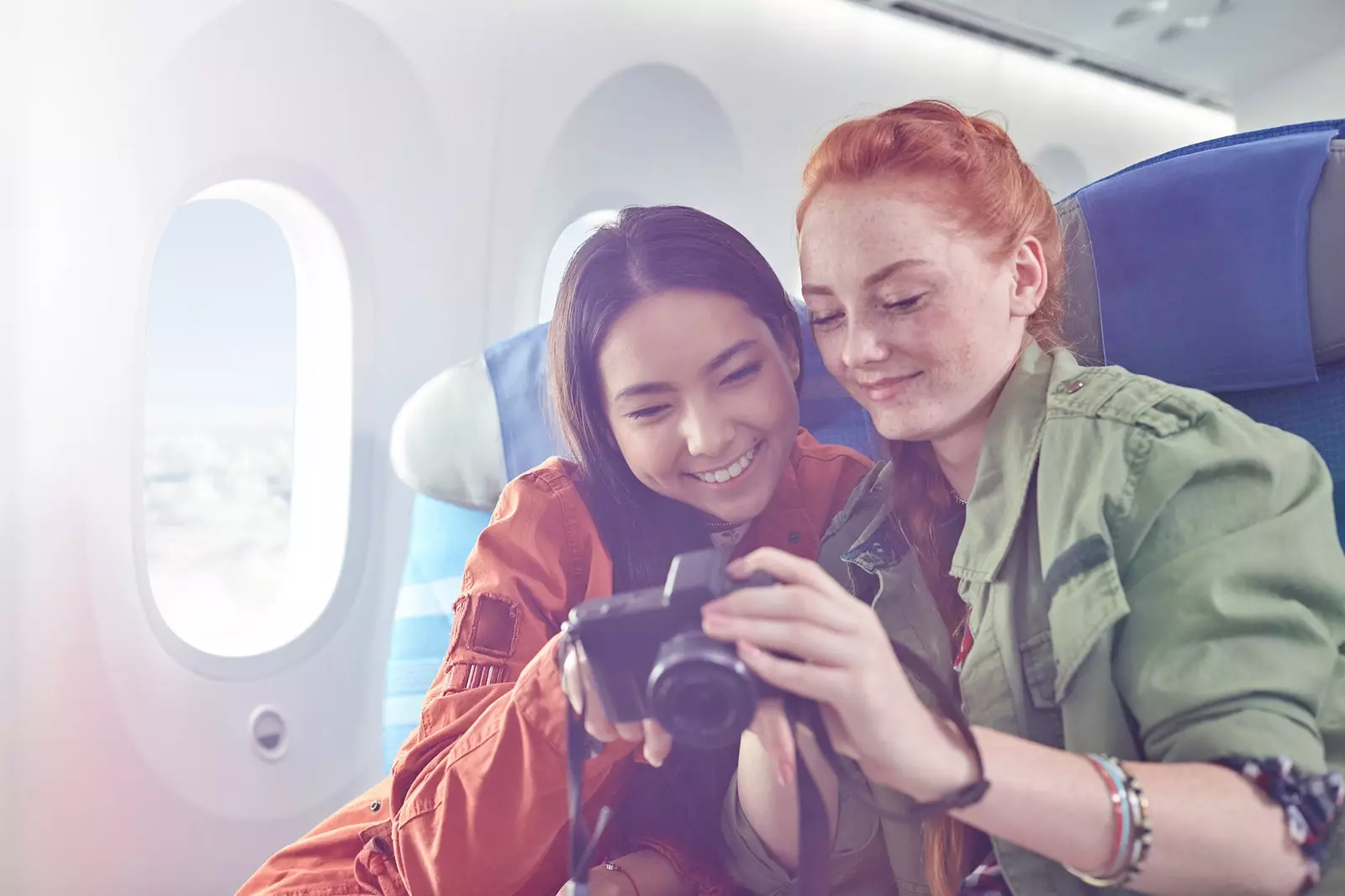 Deux copines regardent des photos dans un avion