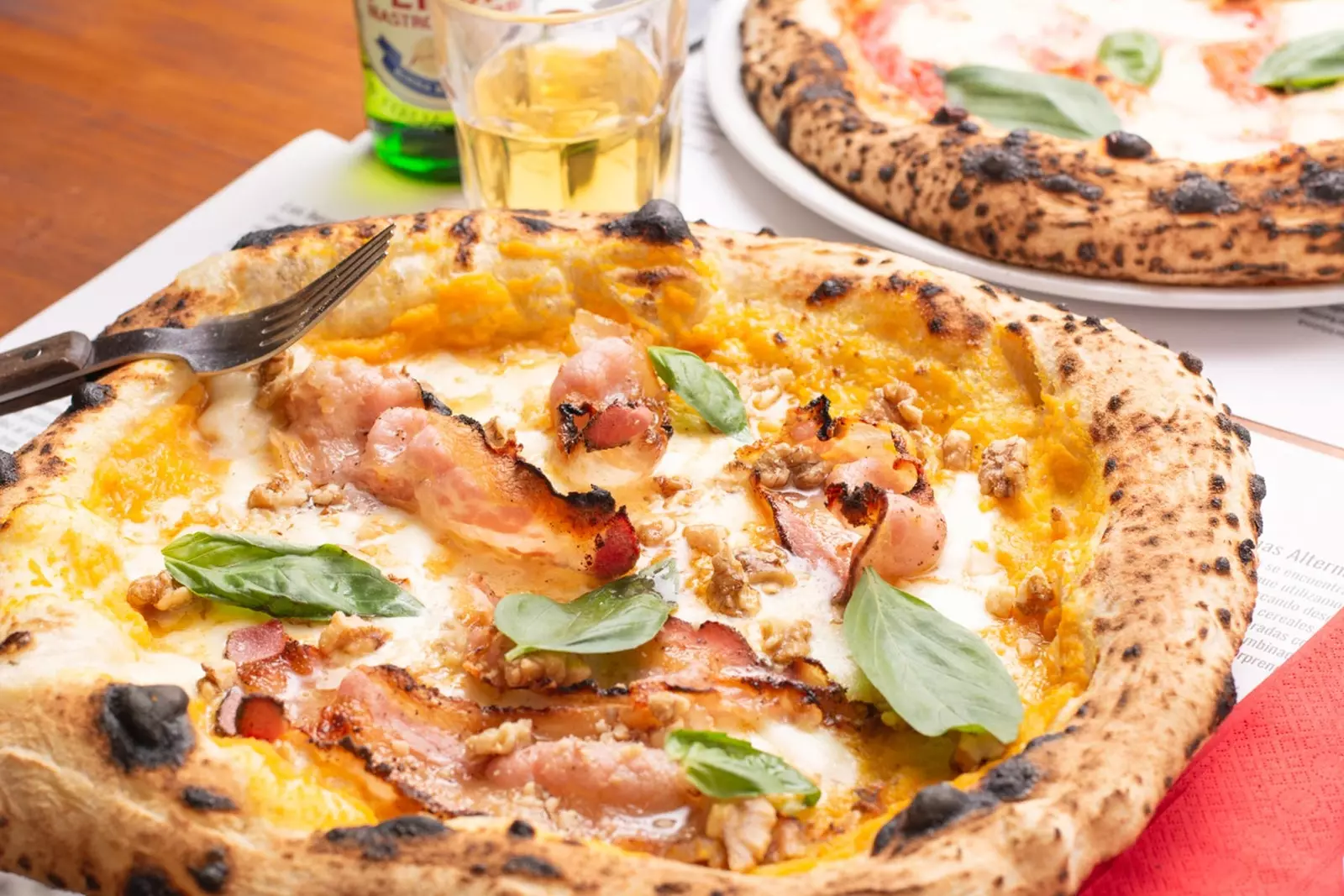 Pizza na cream ya malenge iliyochomwa, mozzarella, bacon crispy, walnuts na basil.