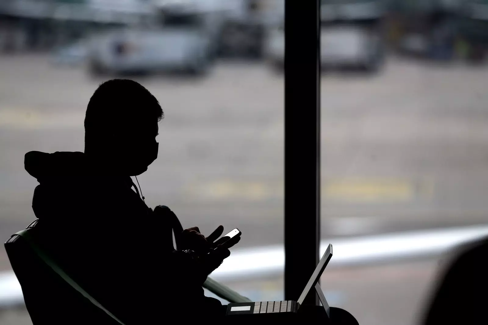 Silhouette di una persona che indossa una maschera che lavora in un aeroporto di Francoforte