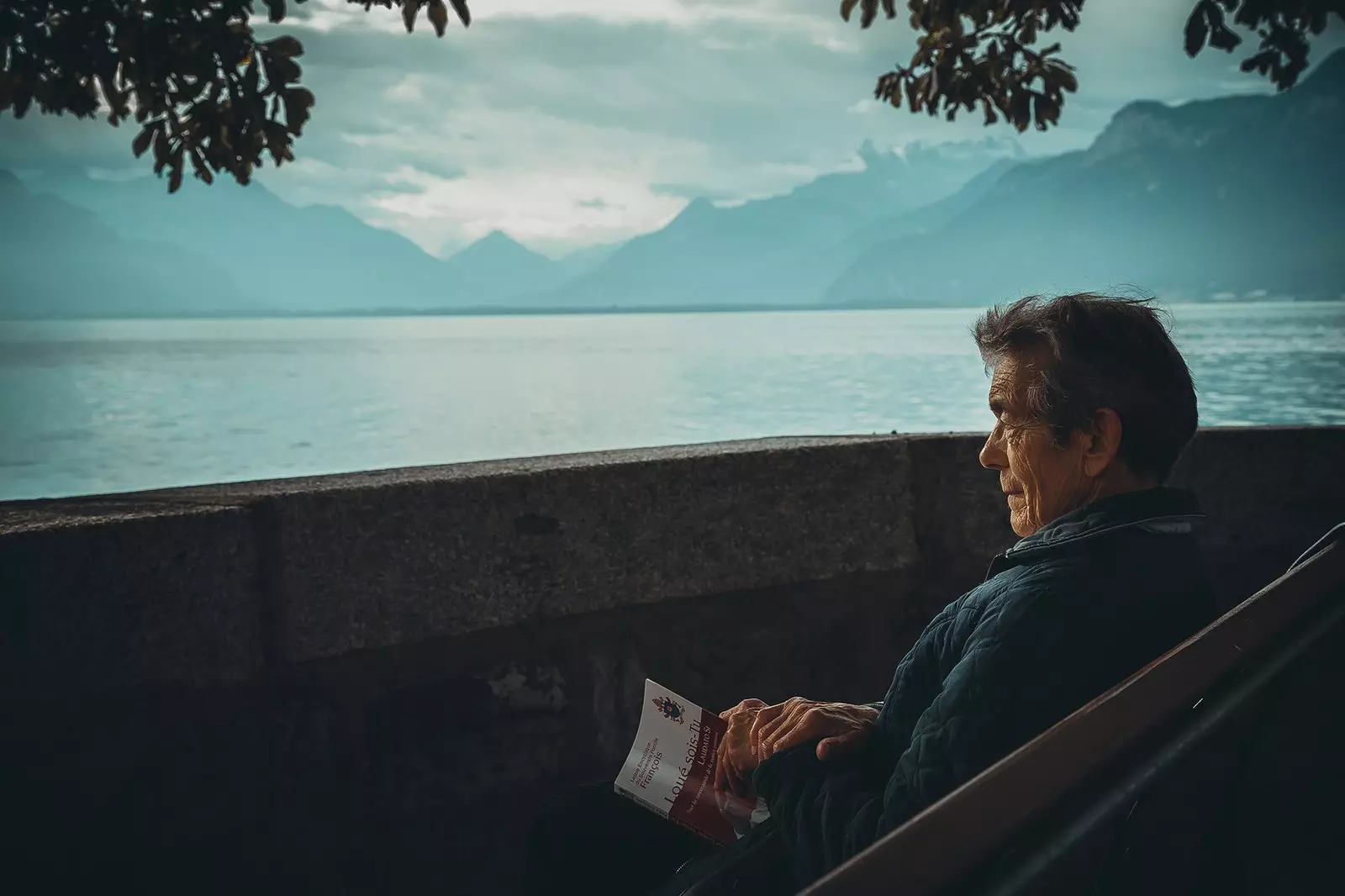 Man reading in front of a lake