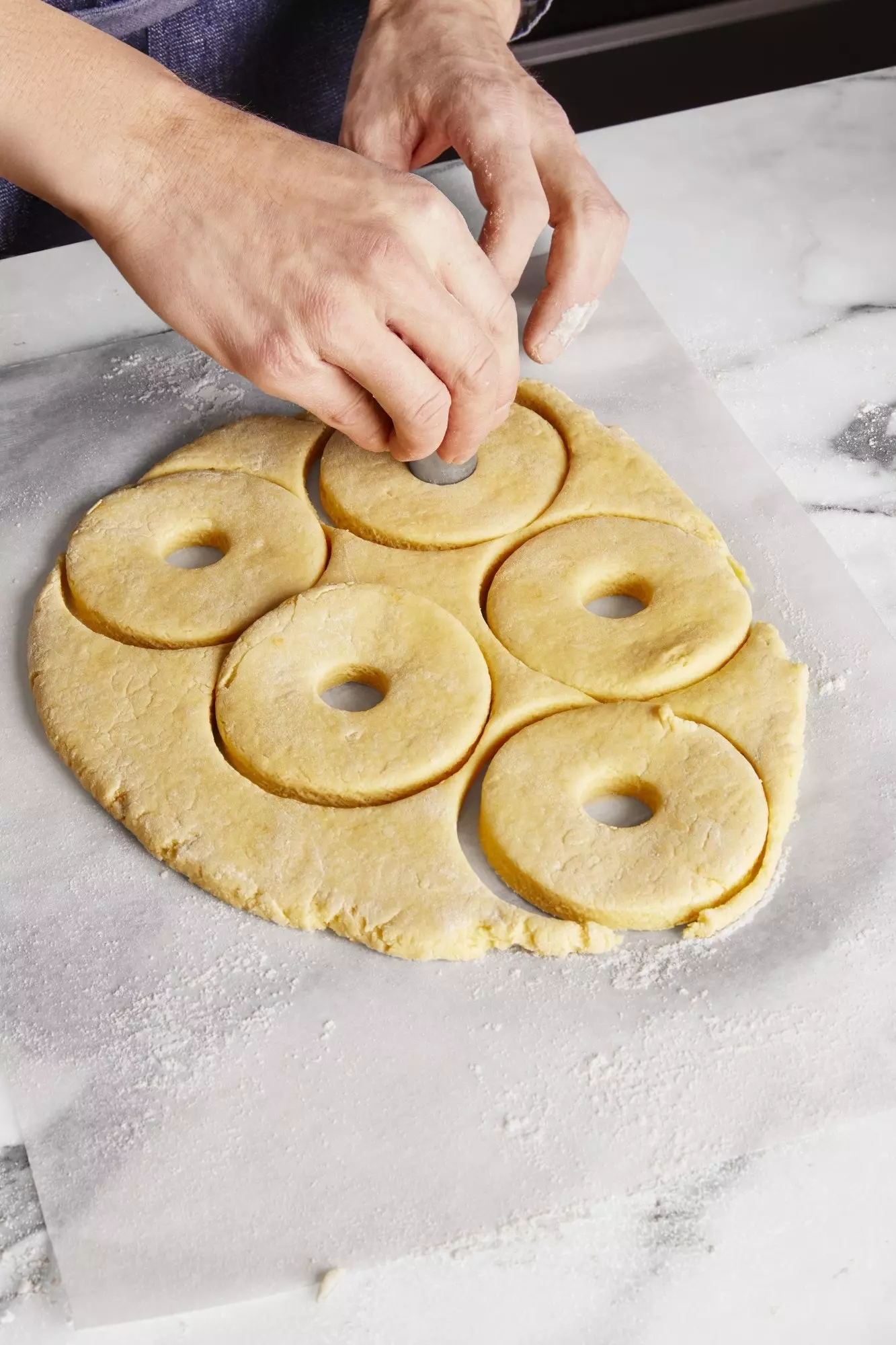 Zorg ervoor dat u overtollig meel verwijdert voordat u de donuts gaat doorboren.